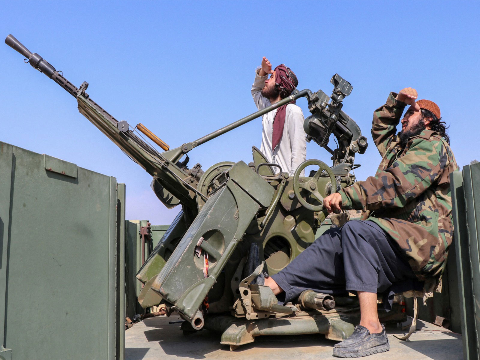 Taliban soldiers sit next to an anti-aircraft gun while on lookout for Pakistan's fighter jets in Afghanistan (Photo/Reuters)