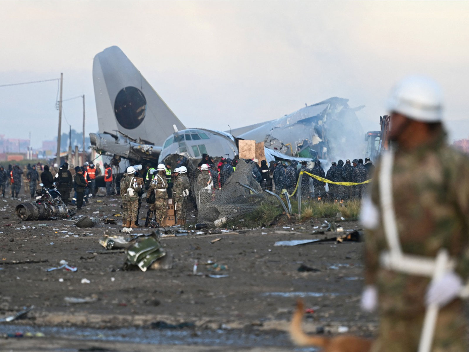 Emergency personnel work at the site after a Bolivian Air Force Hercules aircraft crashed on Friday evening (Photo/Reuters)