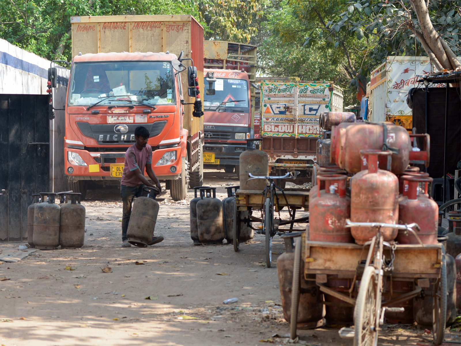 A worker loads refilled Indane LPG cylinders at a distribution depot, in New Delhi (Photo/ANI)