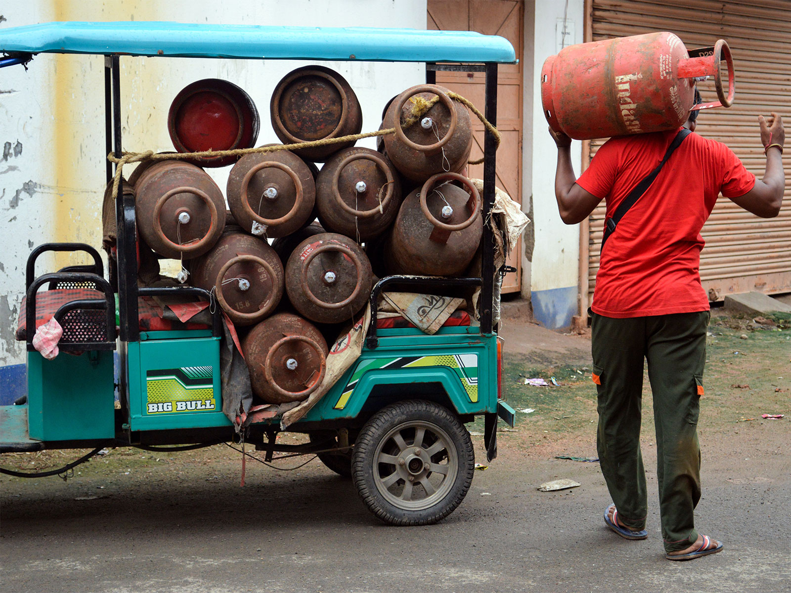 A worker carries LPG gas cylinders for delivery (Photo/ANI)