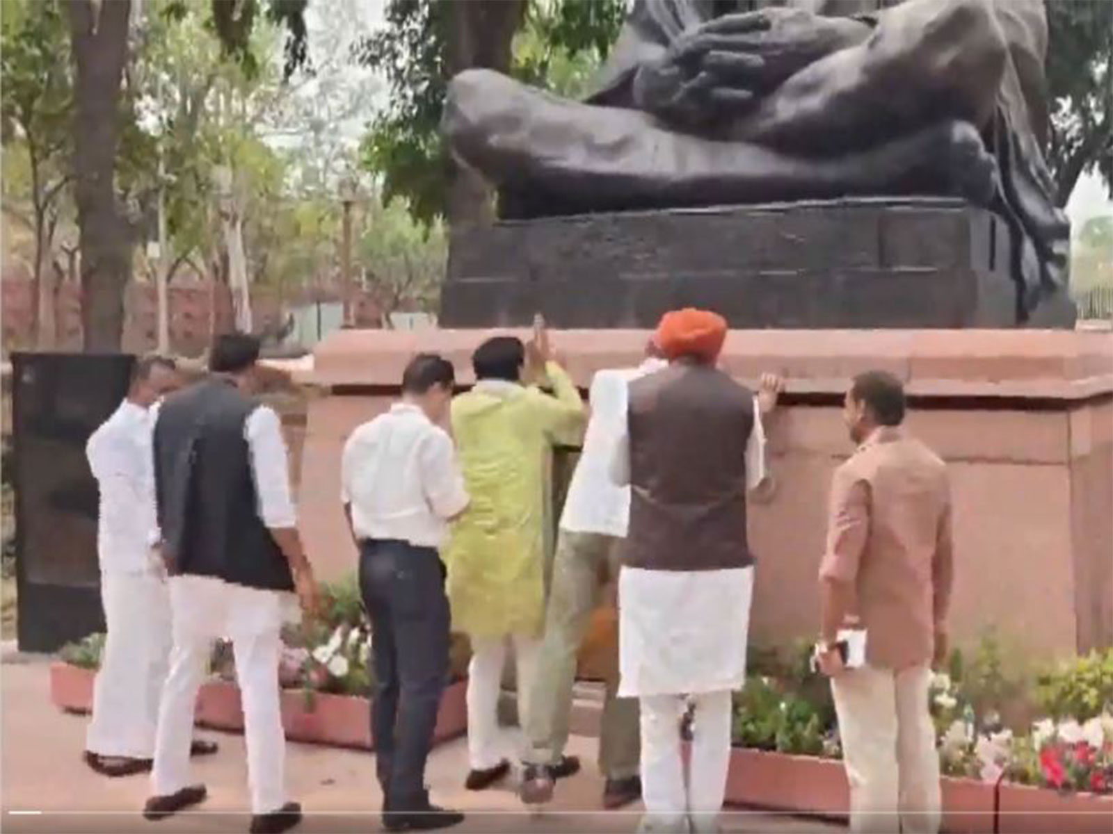Opposition MPs at the statue of Mahatma Gandhi inside Parliament Complex (Photo/ANI)