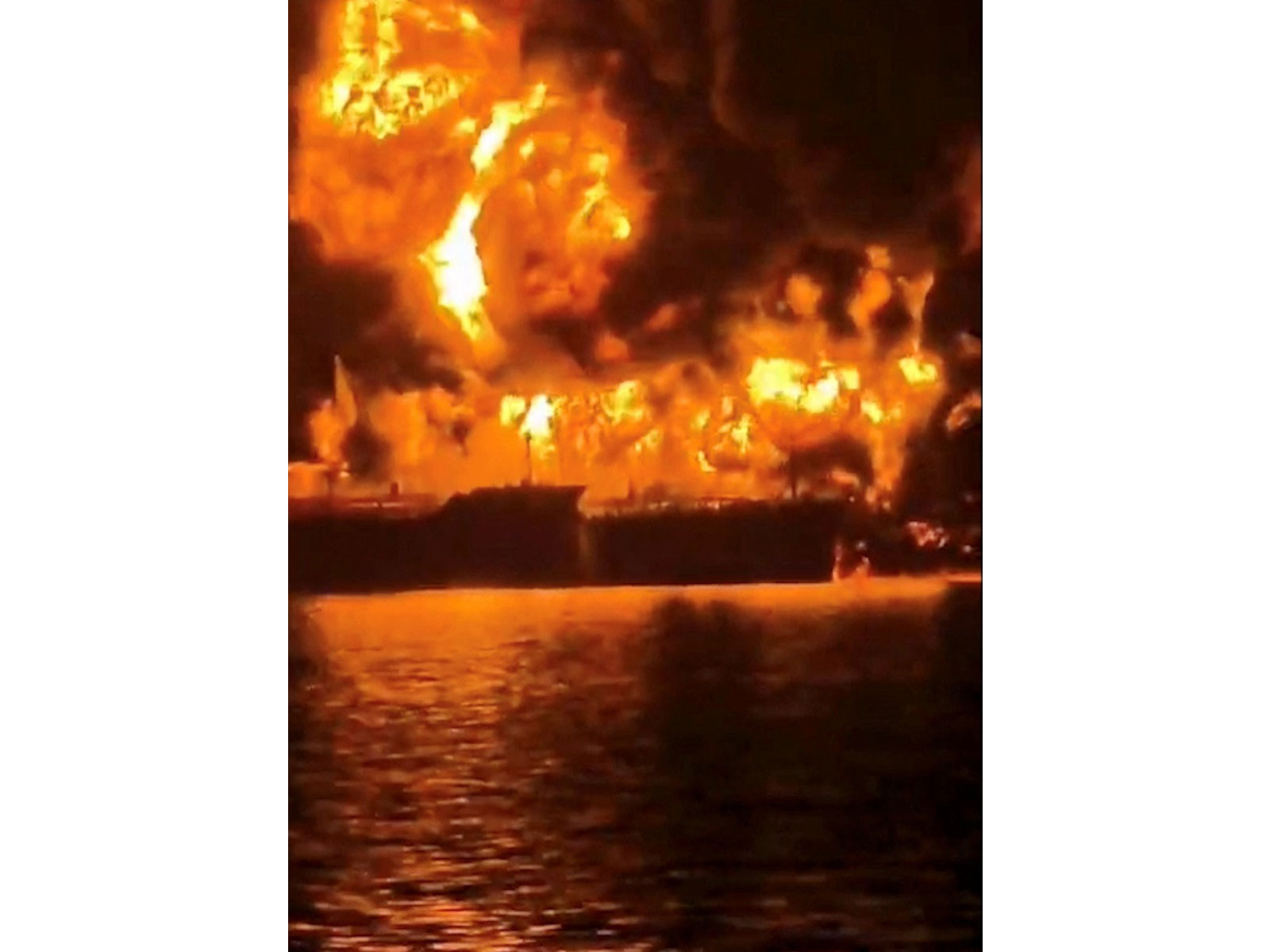 A ship burns, after Iranian explosive-laden boats appear to have attacked two fuel tankers in Iraqi waters (File Photo/ Reuters via Media Office of Iraqi Ports)