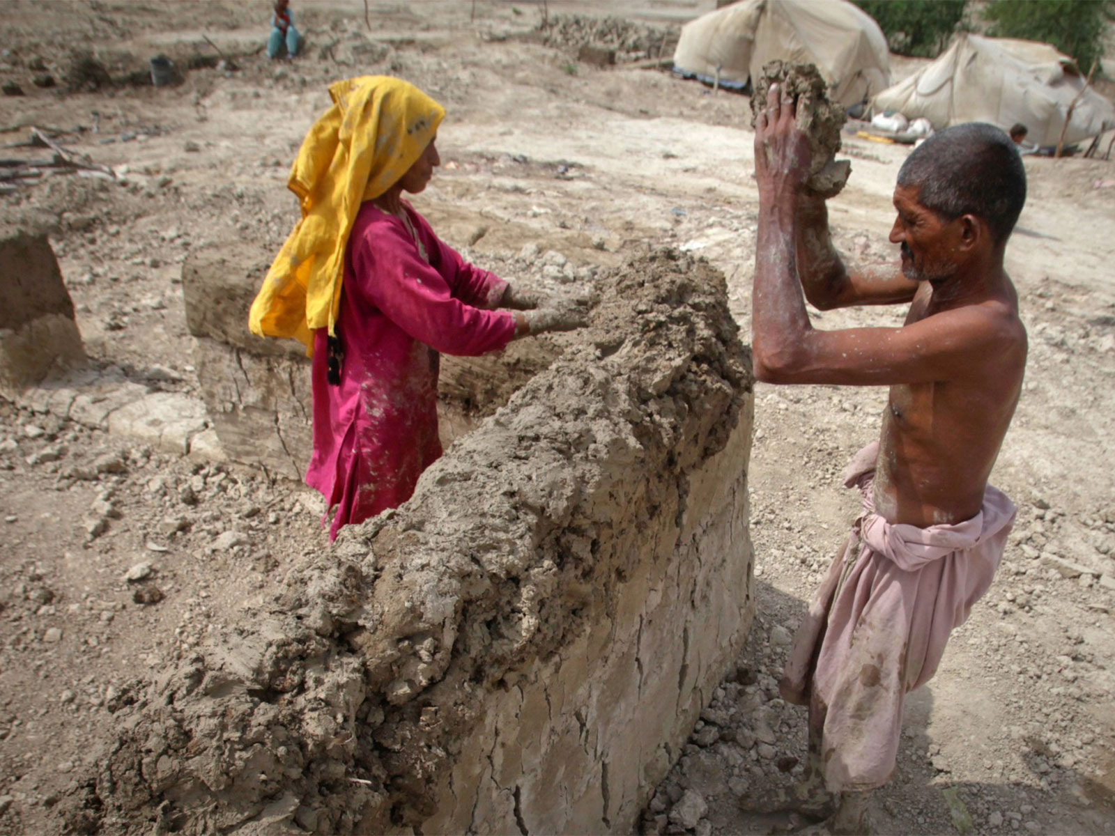A man builds a mud house with his wife in Ali Murad Mugheri village Pakistan (File Photo/ Reuters)