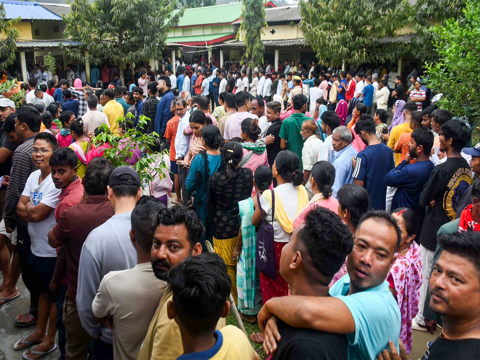 Voters wait in queues to cast their votes at a polling station in Assam.  (Photo/ANI)