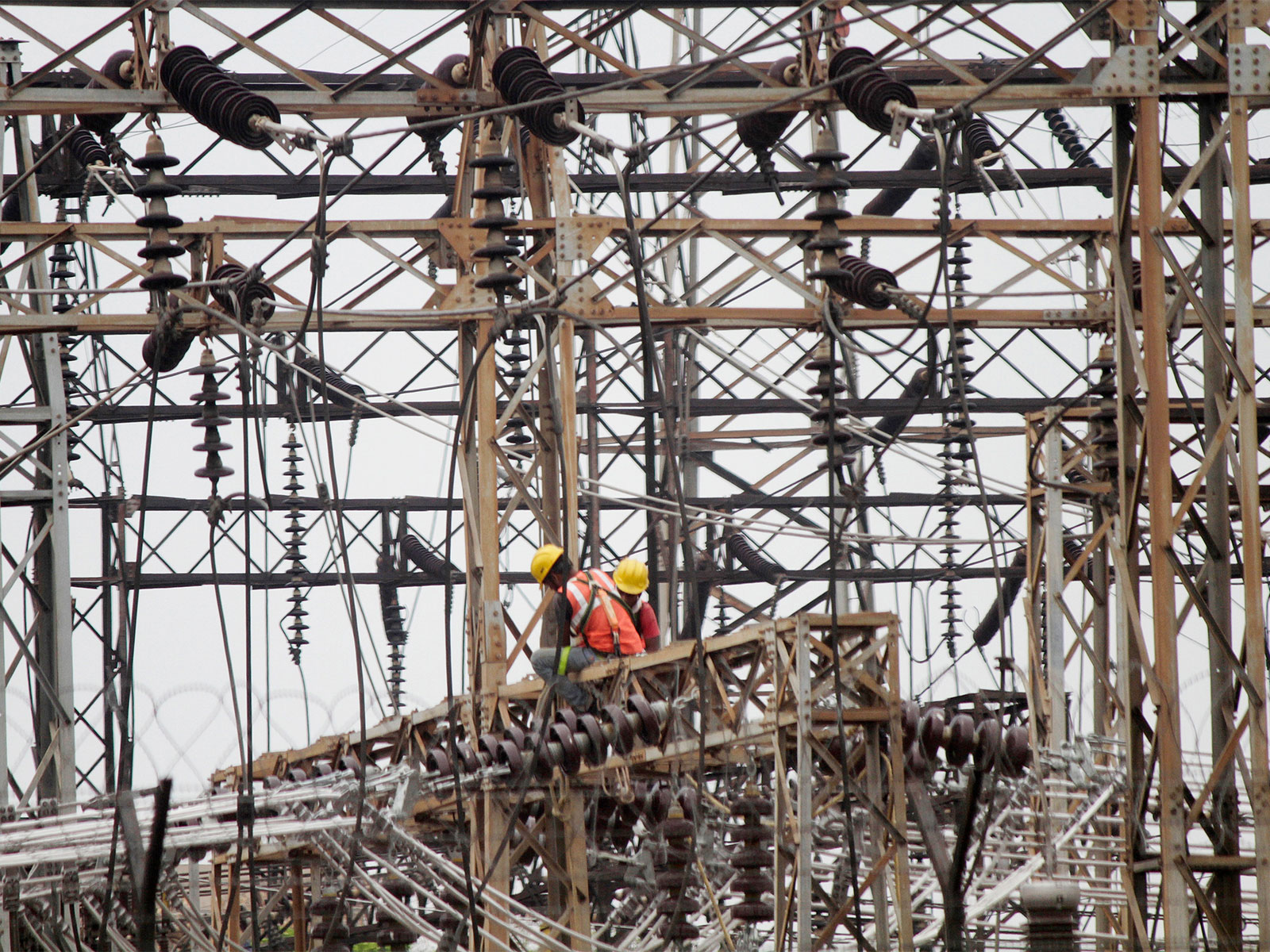 Employees work on electric pylons at a power station (File Photo/ANI)