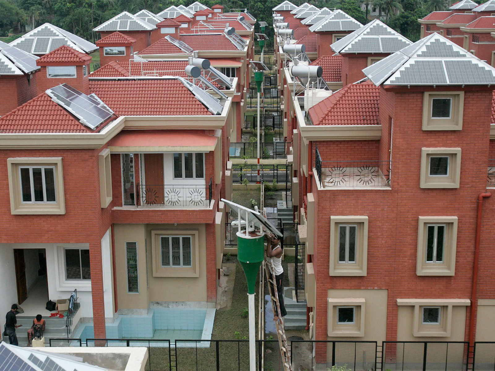 A labourer checks the solar panel of a street light at a newly constructed solar housing complex in Kolkata (Photo/Reuters)