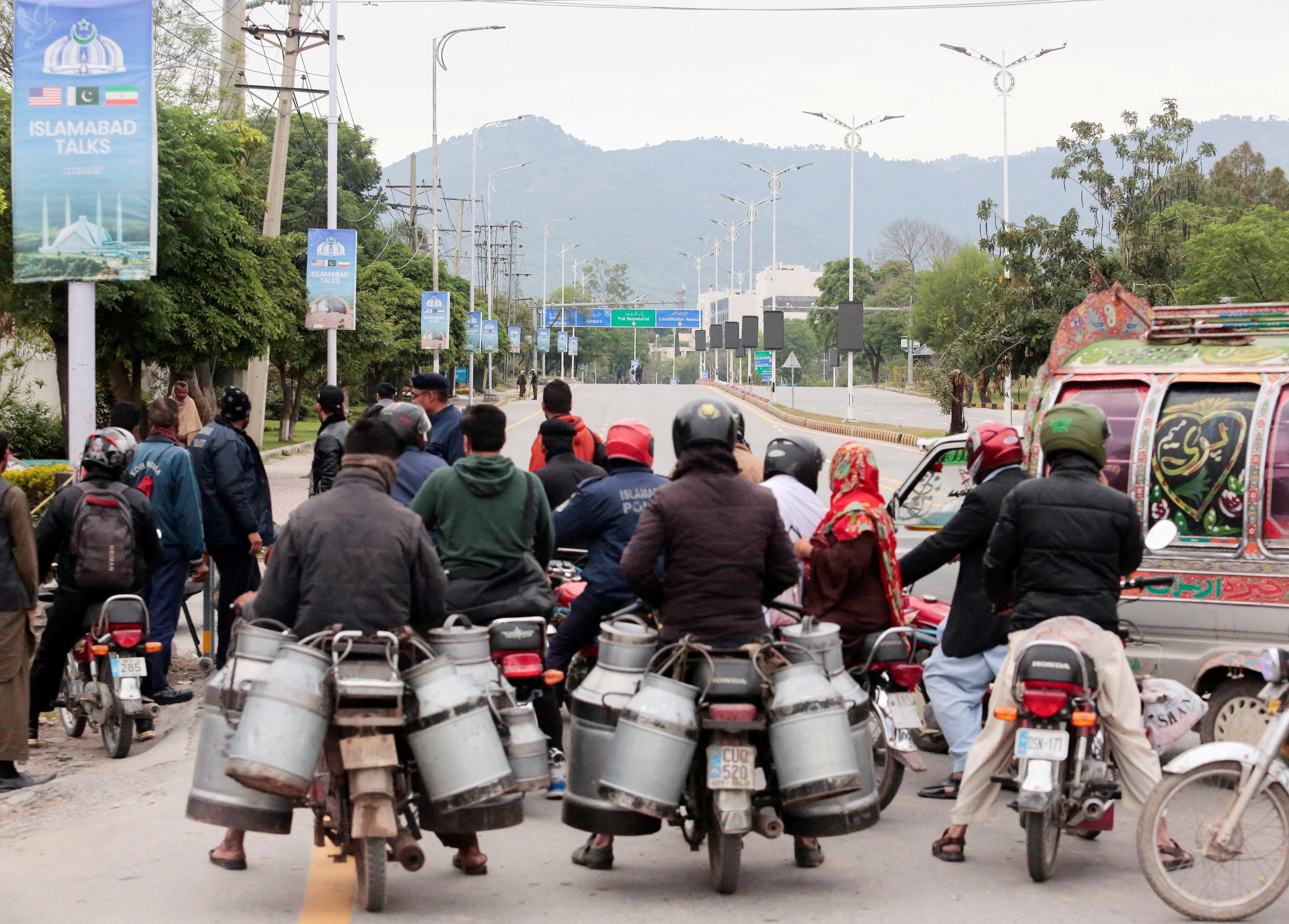 Commuters sit on bikes at a roadblock leading to the Serena Hotel in Pakistan (Photo/Reuters)
