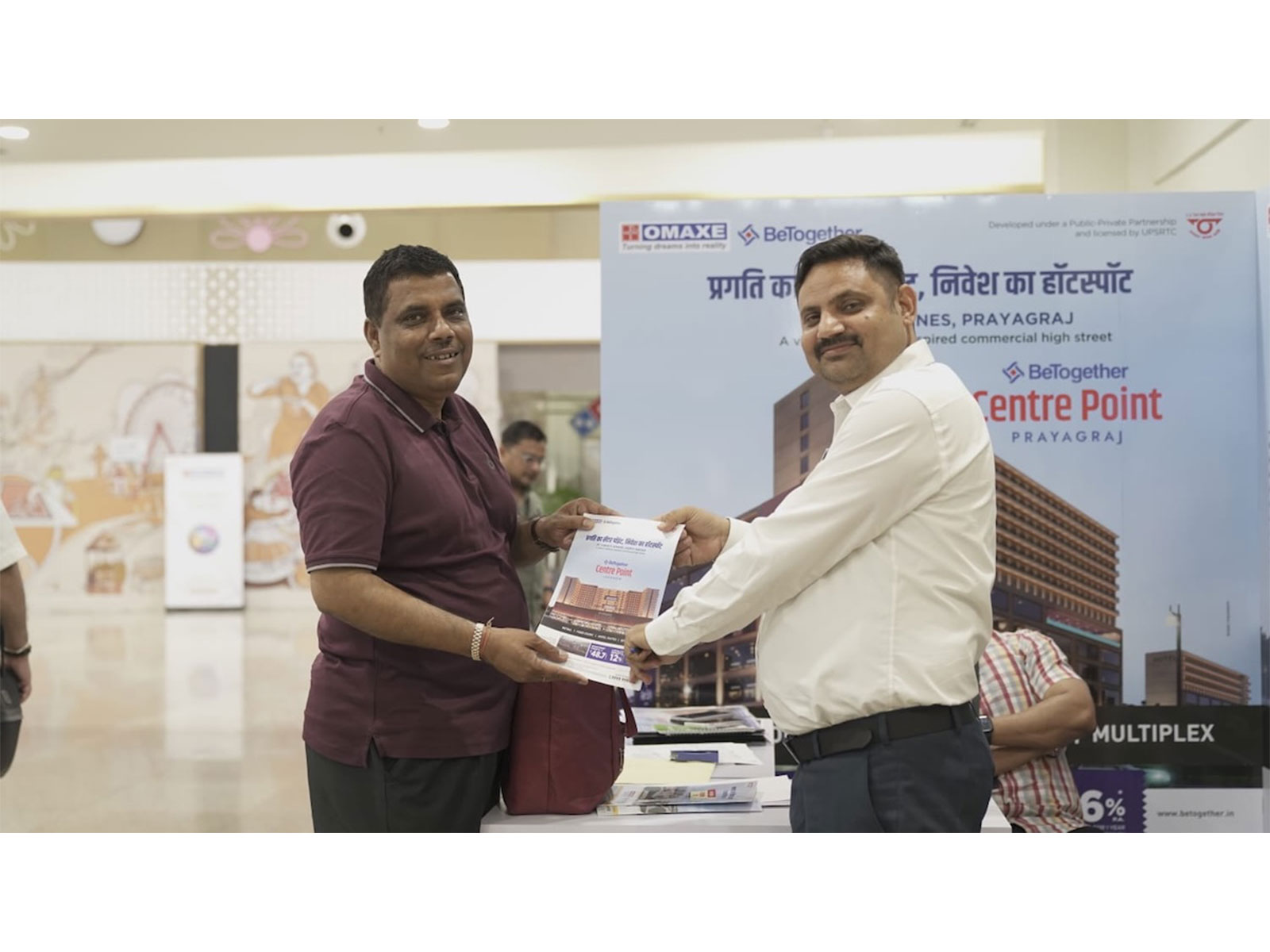 Omaxe BeTogether Centre Point Prayagraj brochure handover at real estate property exhibition stall