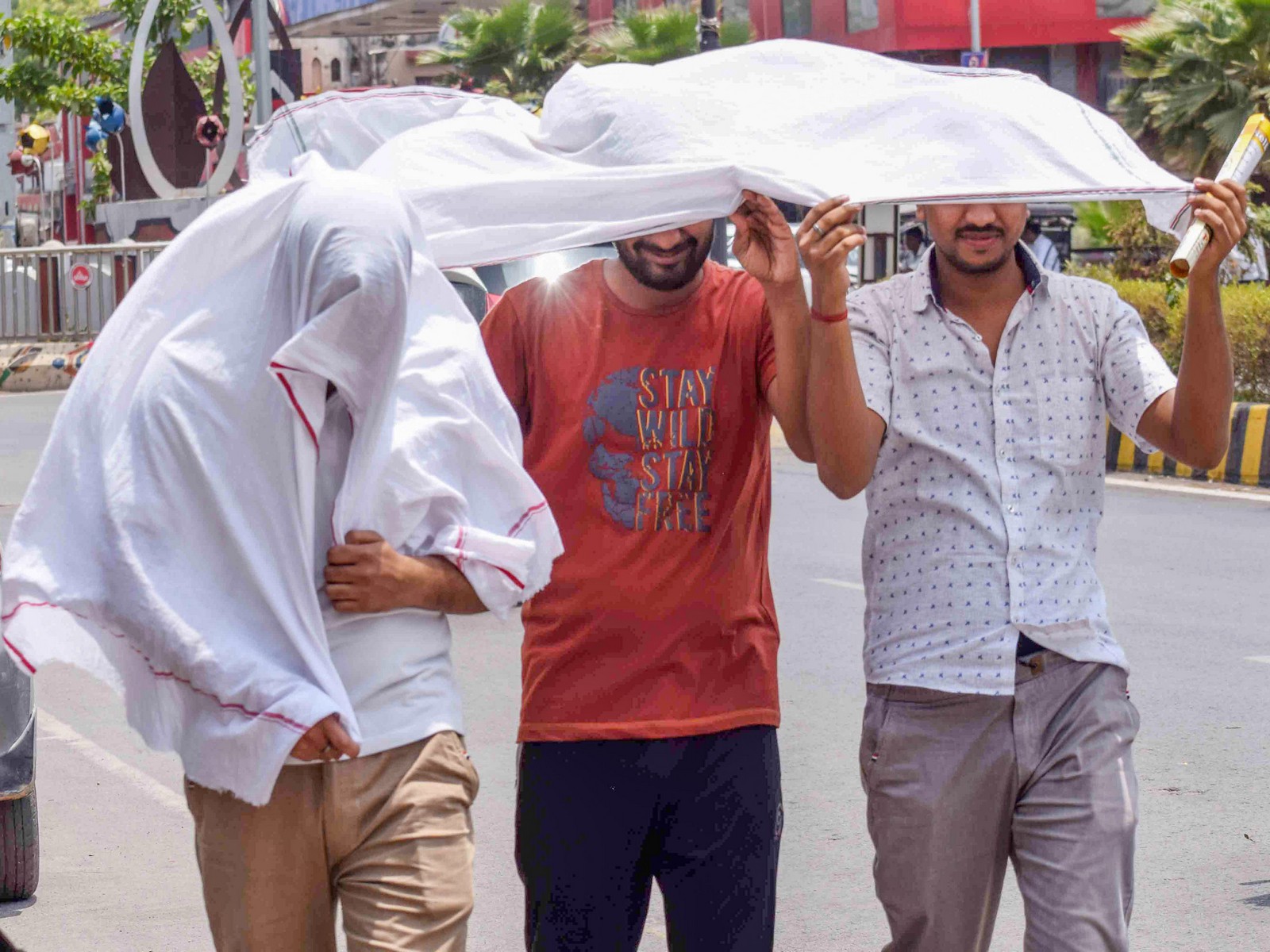 Commuters use scarves to cover themselves from the scorching sun during a hot summer day, in Prayagraj on Sunday (Photo/ANI)