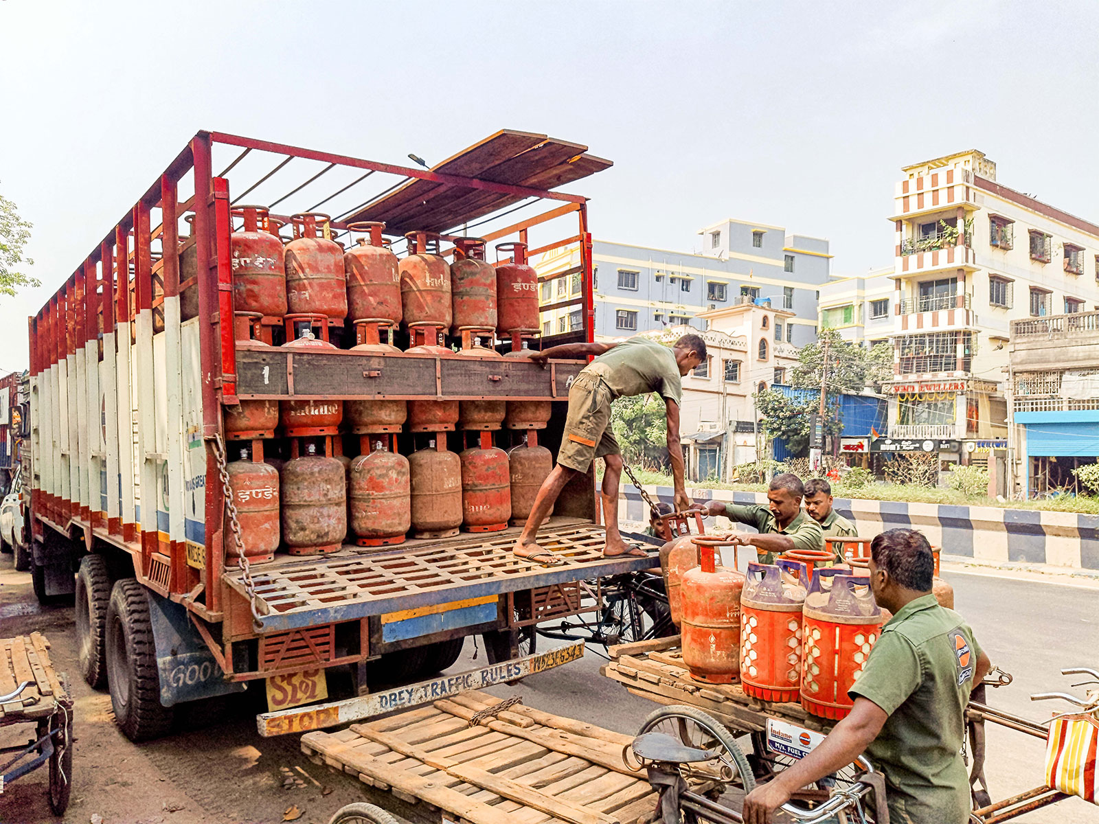 A worker unloads LPG cylinders from a truck at an Indian Oil Corporation LPG distributor facility at Belgharia, Kolkata (Photo/ANI)
