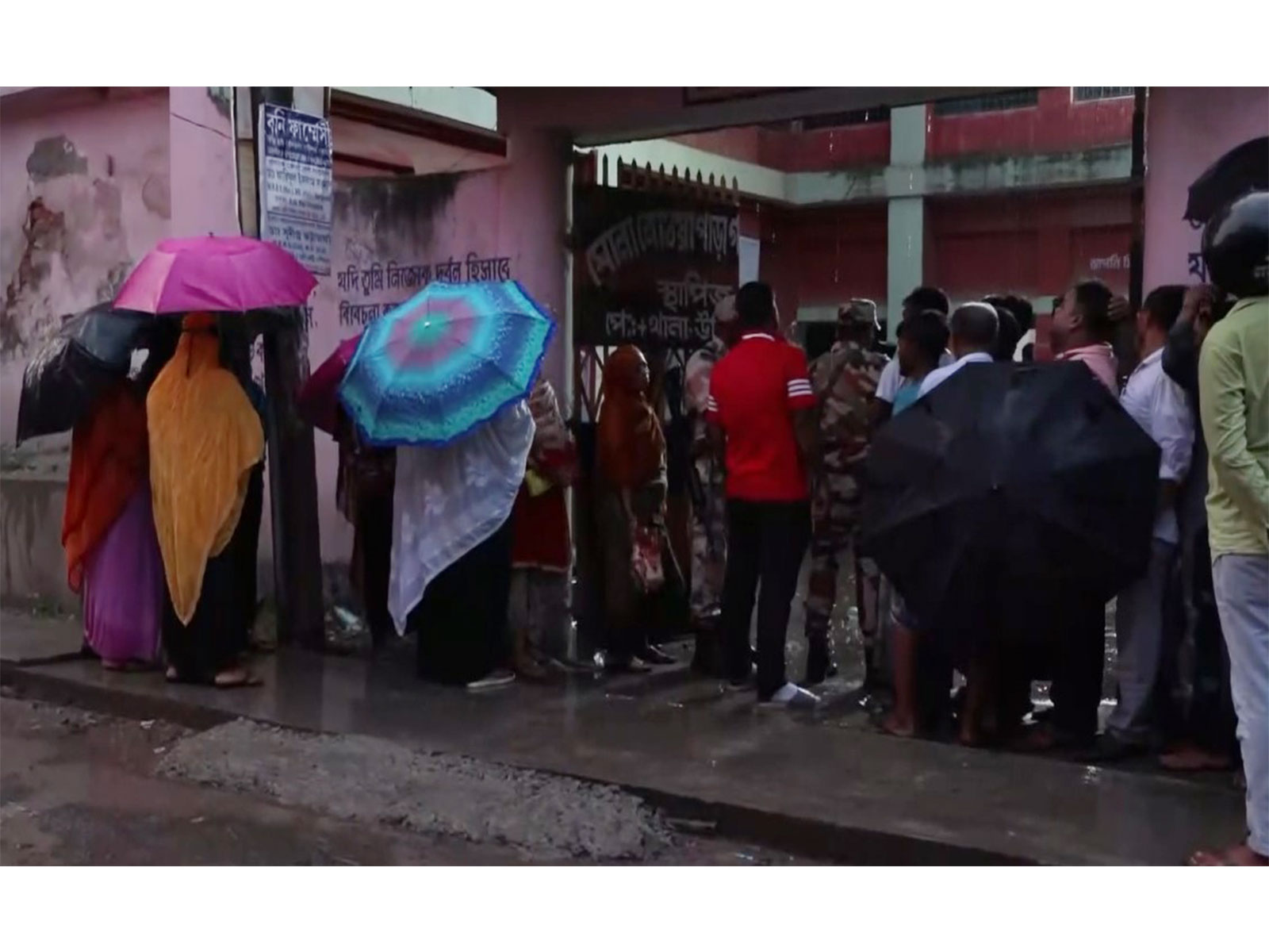 Voters queue up at a polling station in Magrahat Paschim constituency amid rainfall (Photo/ANI)