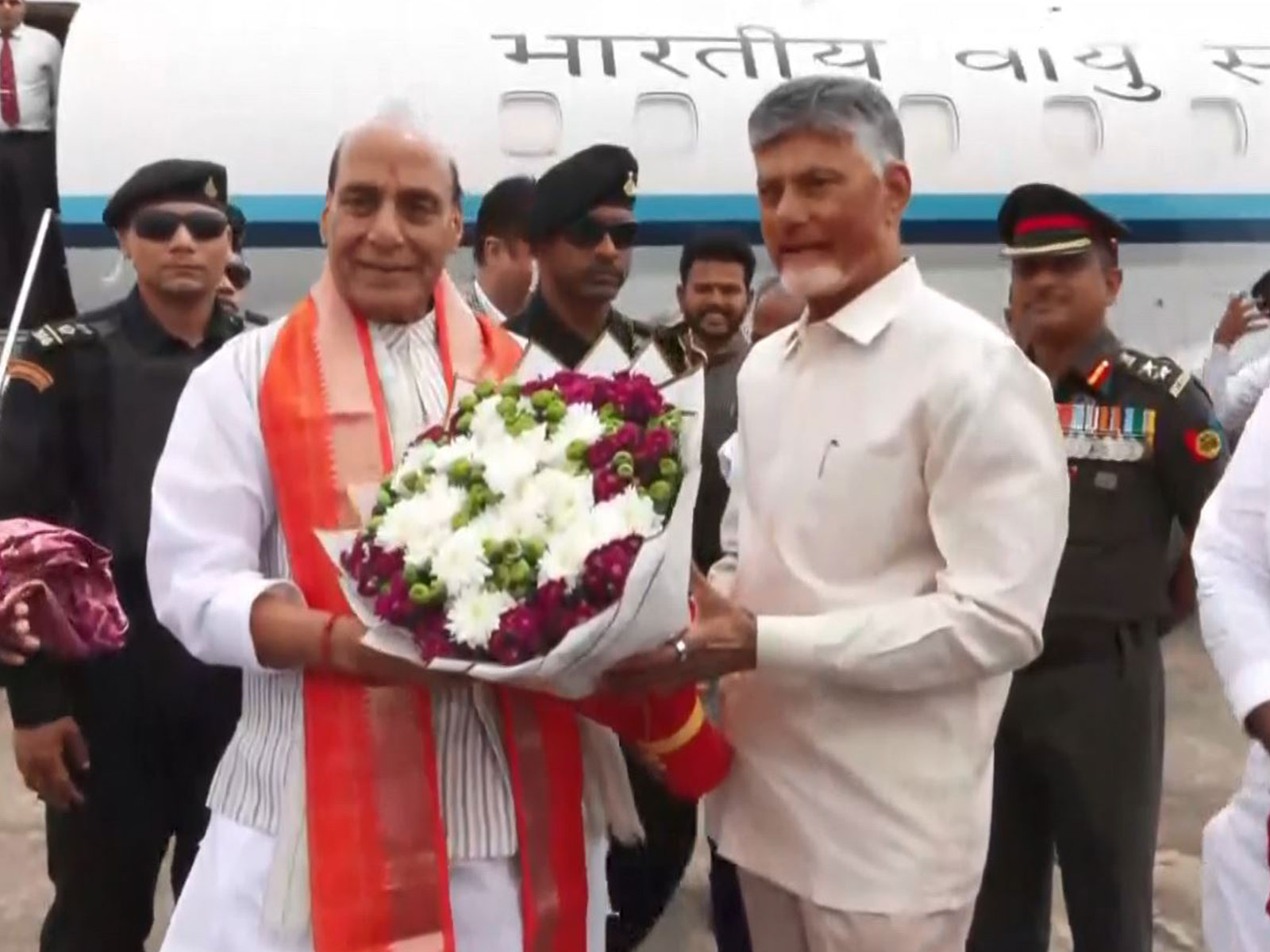 Defence Minister Rajnath Singh being welcomed by Andhra Pradesh Chief Minister Chandrababu Naidu upon his arrival in Puttaparthi (Photo/ANI)