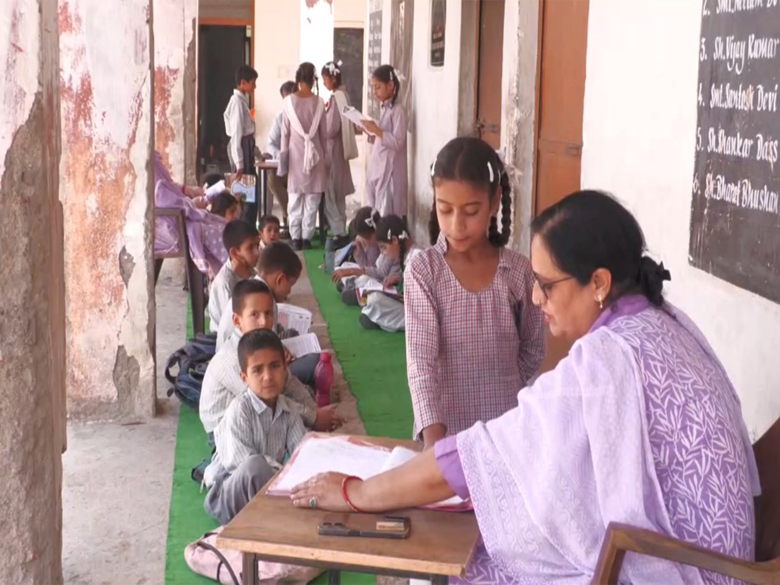 Students studying outside the government middle school due to cracked infrastructure in Udhampur (Photo/ANI) 