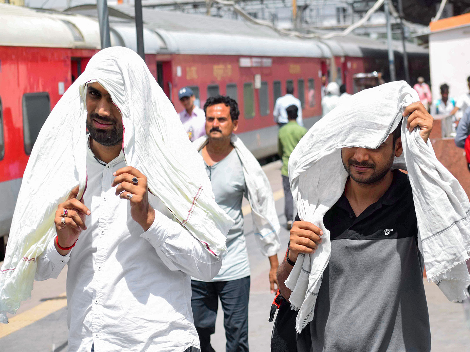 Commuters cover themselves with scarves to beat the scorching heat (Photo/ANI)