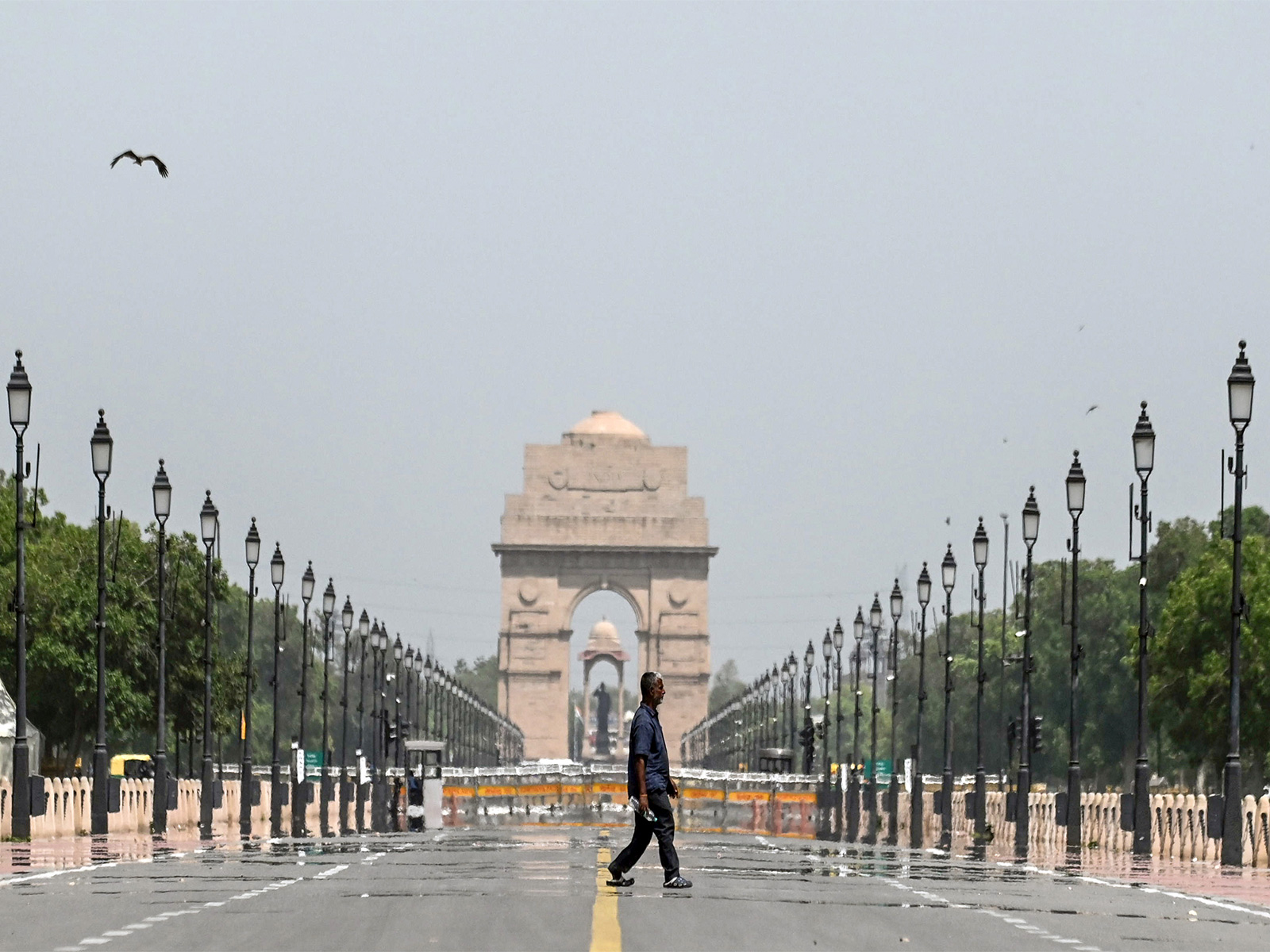 A man walks past the mirages seen at Kartavya Path on a hot summer day, in New Delhi (Photo/ANI)