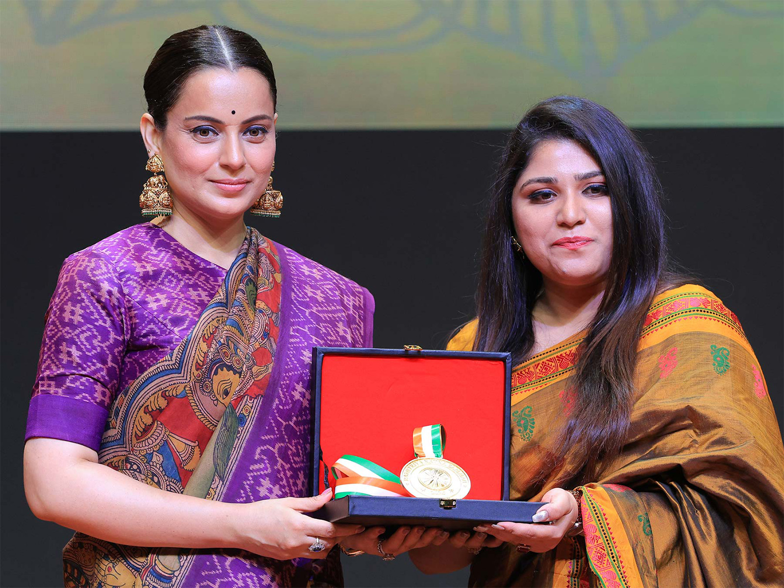 On stage at the Rashtriya Ratna Samman 2026, Dr Karnika Anand, Psychologist (RCI registered), receives the award for 'Most Trusted Psychologist & Mental Wellness Specialist in Delhi' from Ms. Kangana Ranaut.