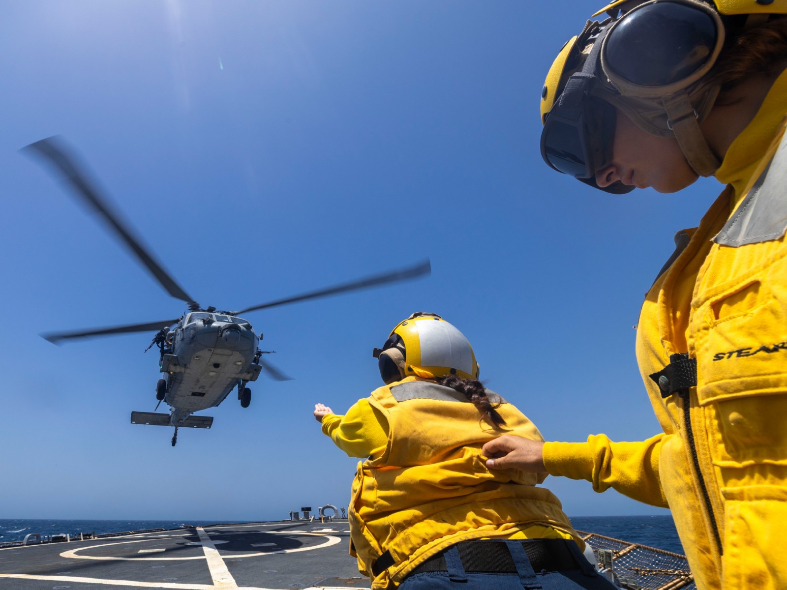 US Sailors guide an MH-60S Sea Hawk helicopter onto the flight deck of USS Milius during operations supporting the US naval blockade on Iran. (Photo: X/@CENTCOM)
