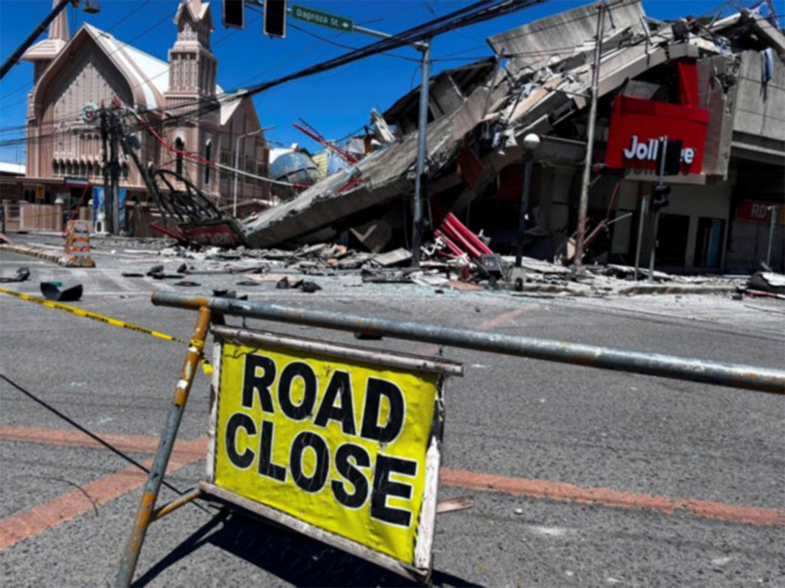 A road closure signage is placed near a collapsed building after a magnitude 7.8 quake in Philippines (Photo/Reuters)