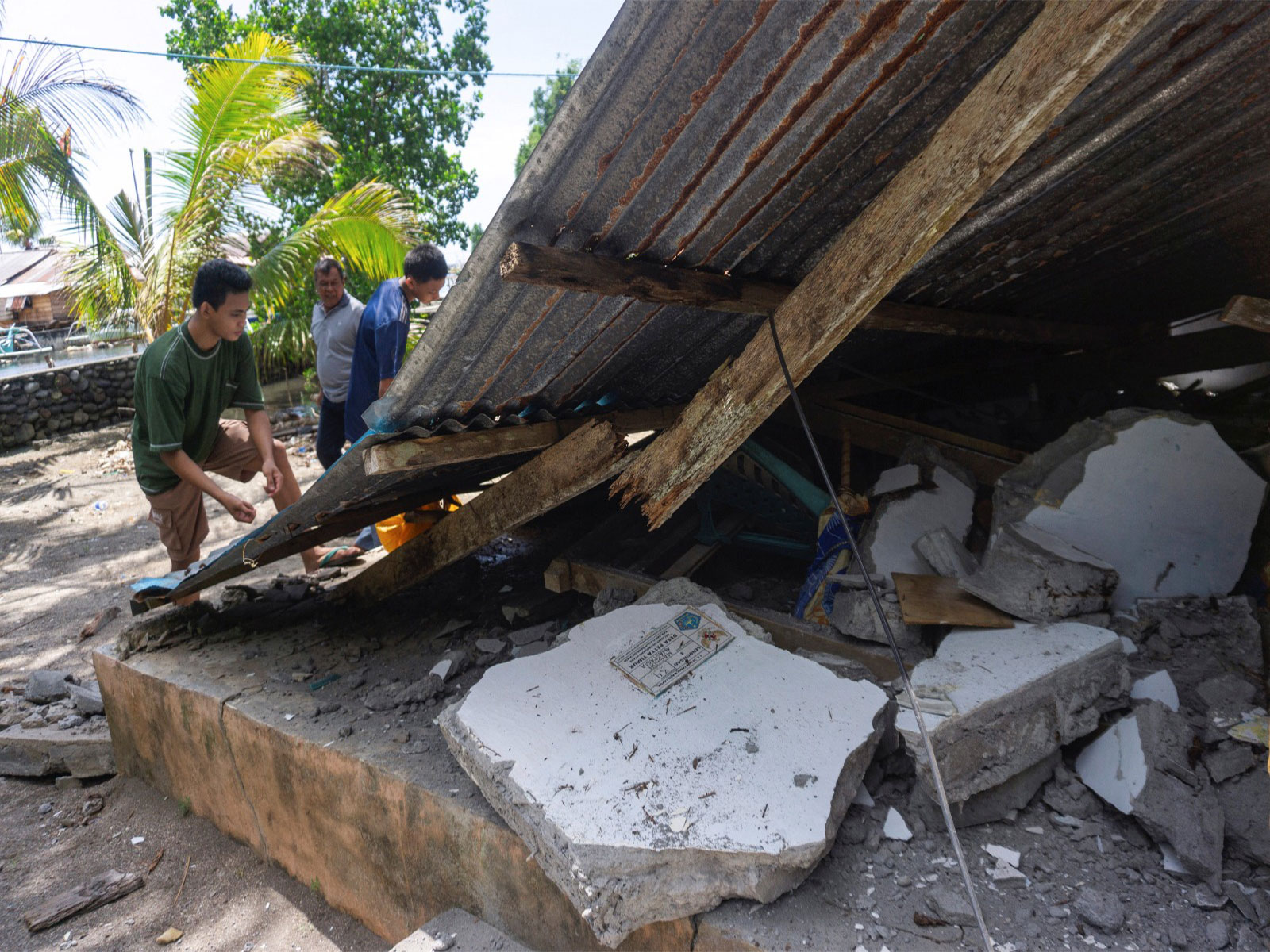 People collect their belongings from a damaged house following an earthquake off the southern Philippine island of Mindanao that was also felt in North Tabukan, Sangihe Islands regency, North Sulawesi province, Indonesia (Photo/Reuters)