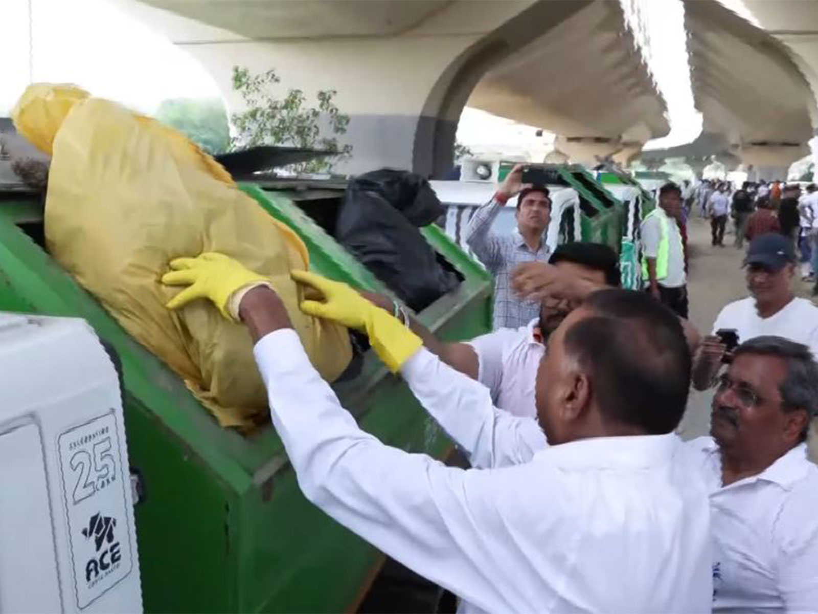 BJP leaders Ramvir Singh Bidhuri and Satish Upadhyay dispose of collected waste in a garbage truck during Yamuna cleanliness drive at Sarai Kale Khan (Photo/ANI)