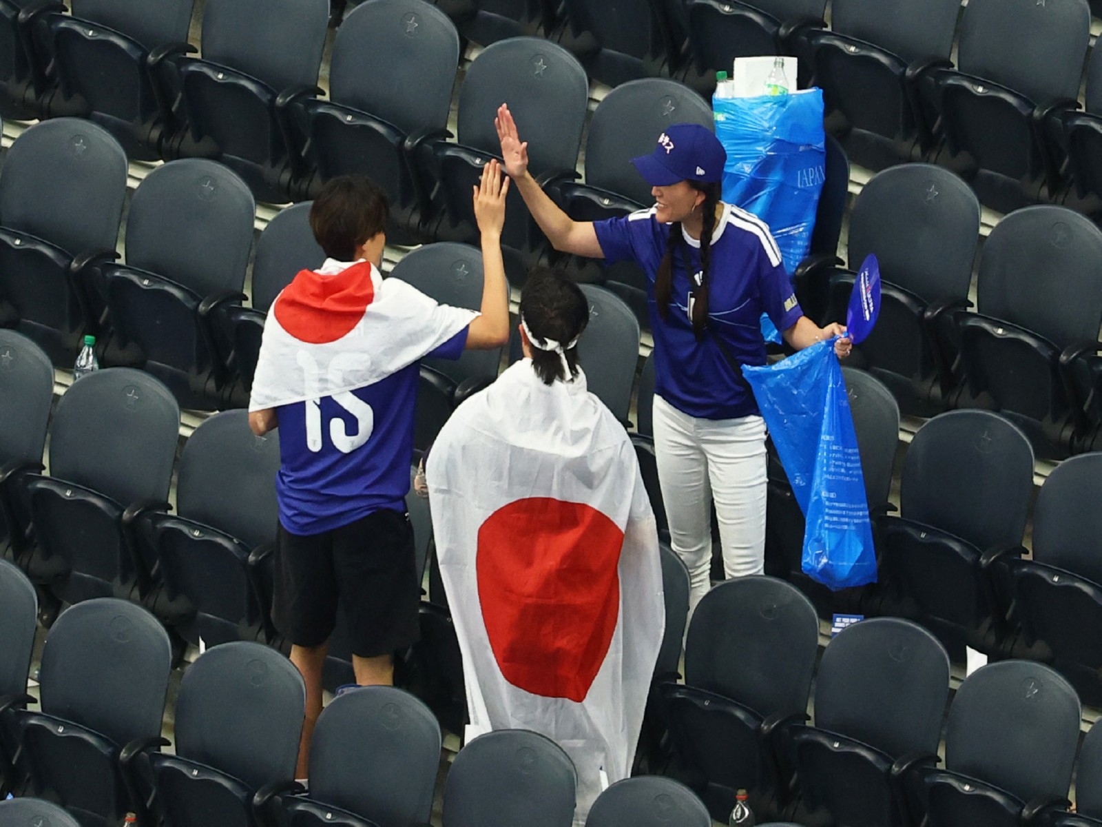 Football - FIFA World Cup 2026 - Group F - Netherlands v Japan - Dallas Stadium, Arlington, Texas, U.S. - June 14, 2026 Japan fans clear rubbish from the stands after the match. (Photo: Reuters/Kai Pfaffenbach)