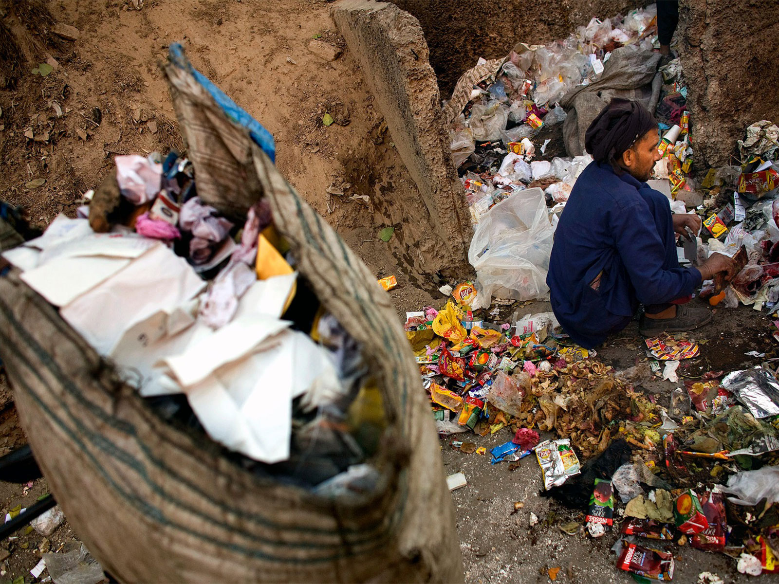 Man sifts through medical waste on a small garbage dump in central Lahore (File Photo/ Reuters)