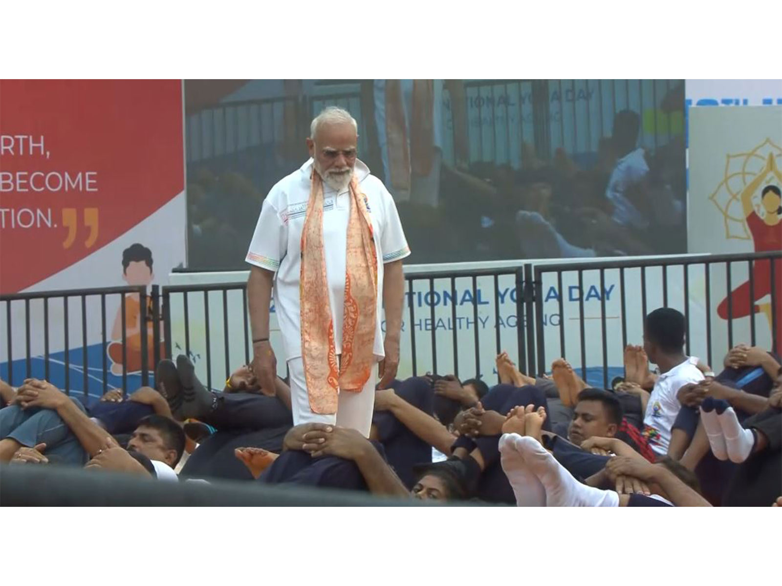 PM Narendra Modi helps participants correct their posture as they perform yoga (Photo/DD)