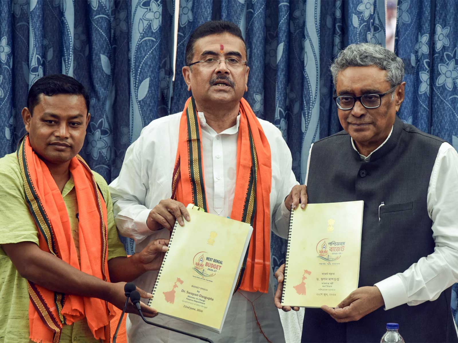 West Bengal CM Suvendu Adhikari, accompanied by State Finance Minister Swapan Dasgupta (right) and BJP MLA Anandamay Barman Hold Budget 2026 Book After Assembly Meeting (Photo/ANI)