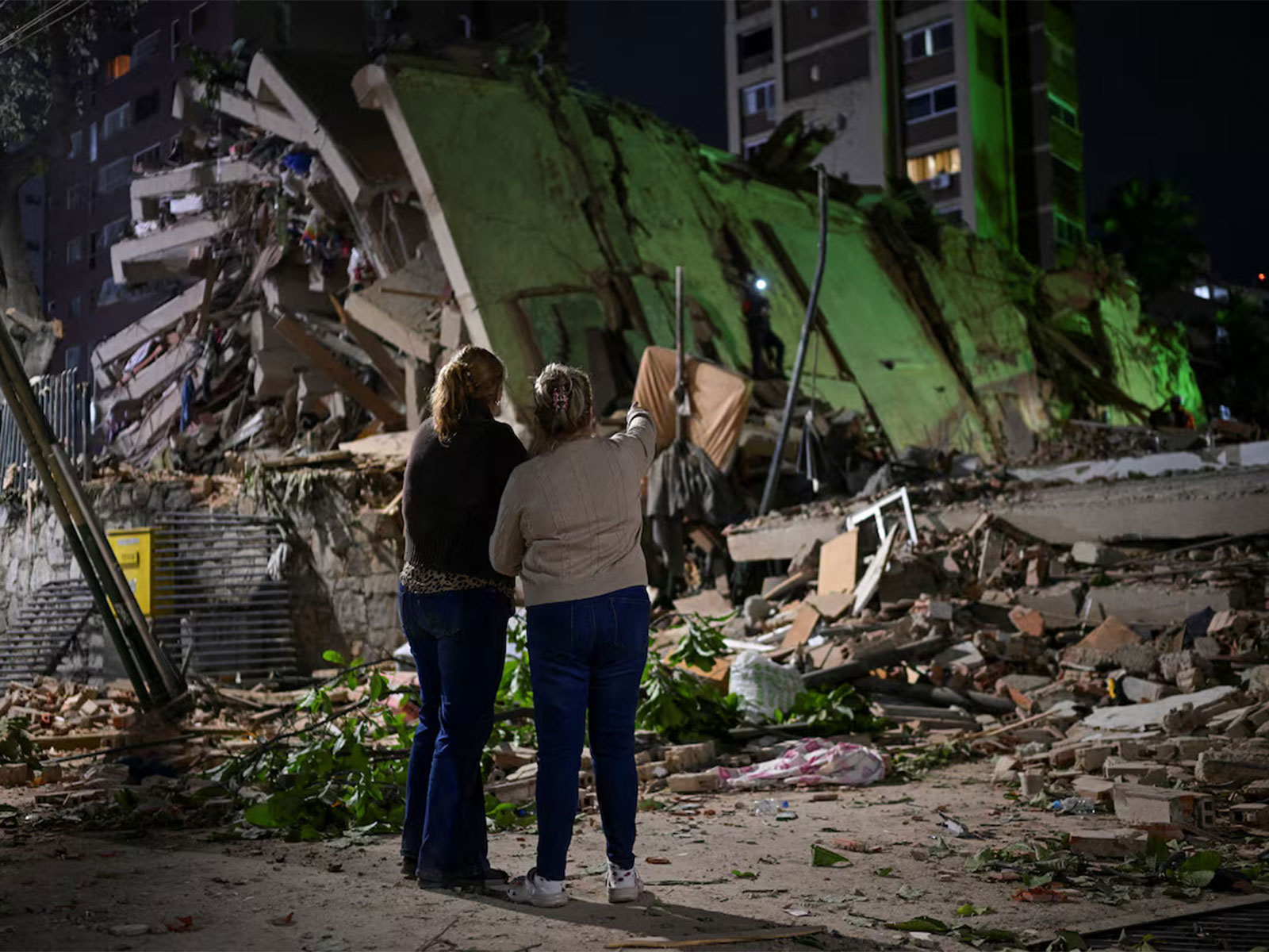 Residents look on as a collapsed building lies in ruins following a powerful earthquake, amid ongoing rescue efforts in Venezuela. (Photo/Reuters)
