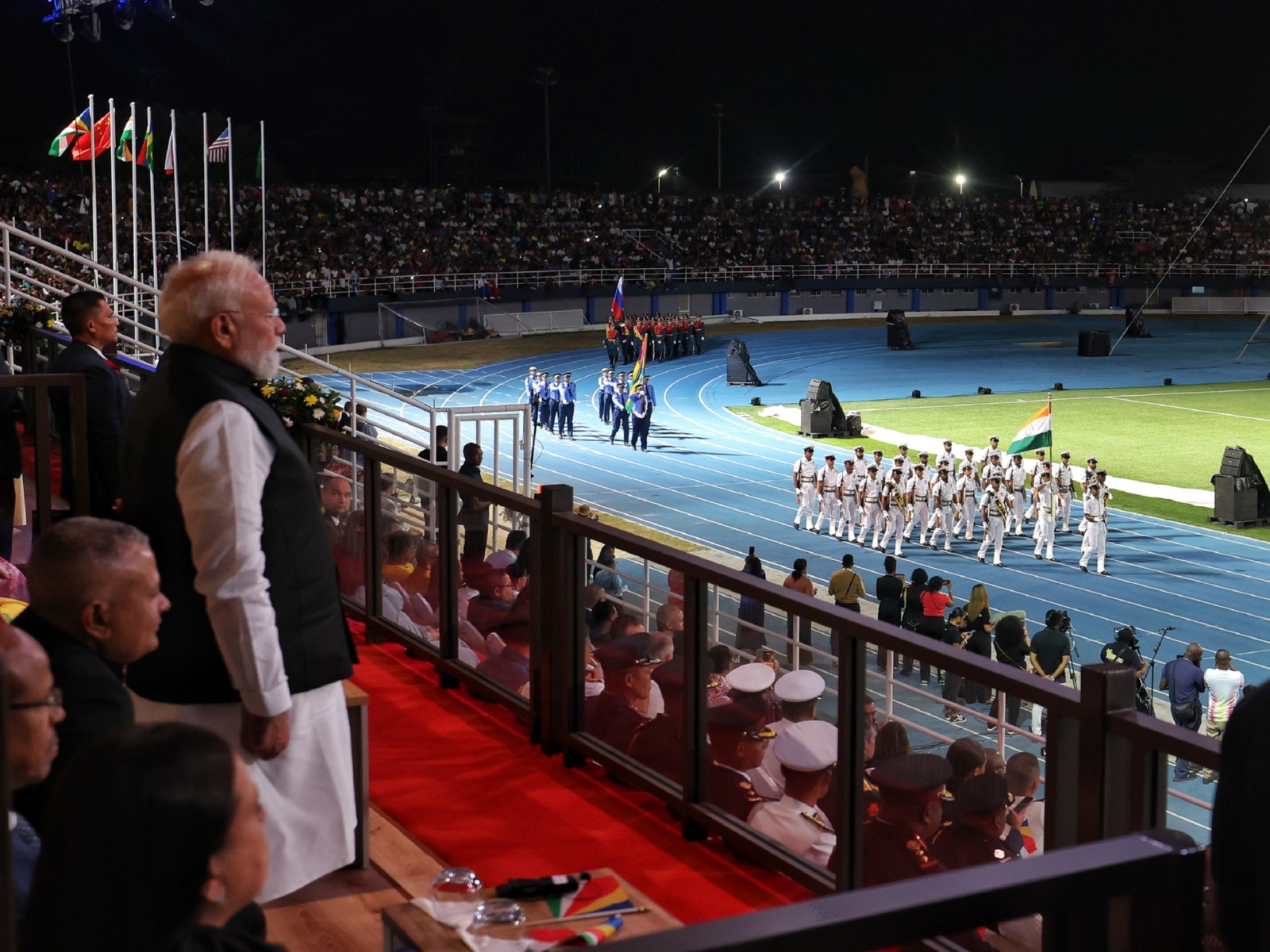 Prime Minister Narendra Modi stands in tribute to the Indian Army and Navy contingents as they march during Seychelles' 50th Independence Day celebrations. (Photo: X/@narendramodi)
