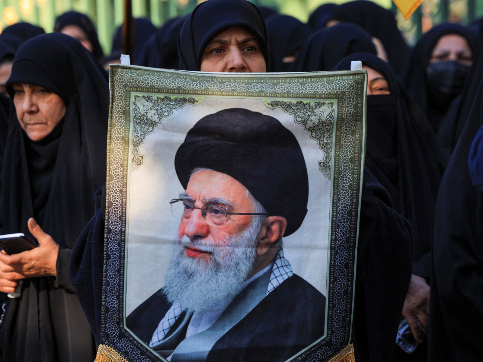Supporters holding a banner of Iran's former Supreme Leader Ayatollah Seyyed Ali Khamenei (File Photo/Reuters)