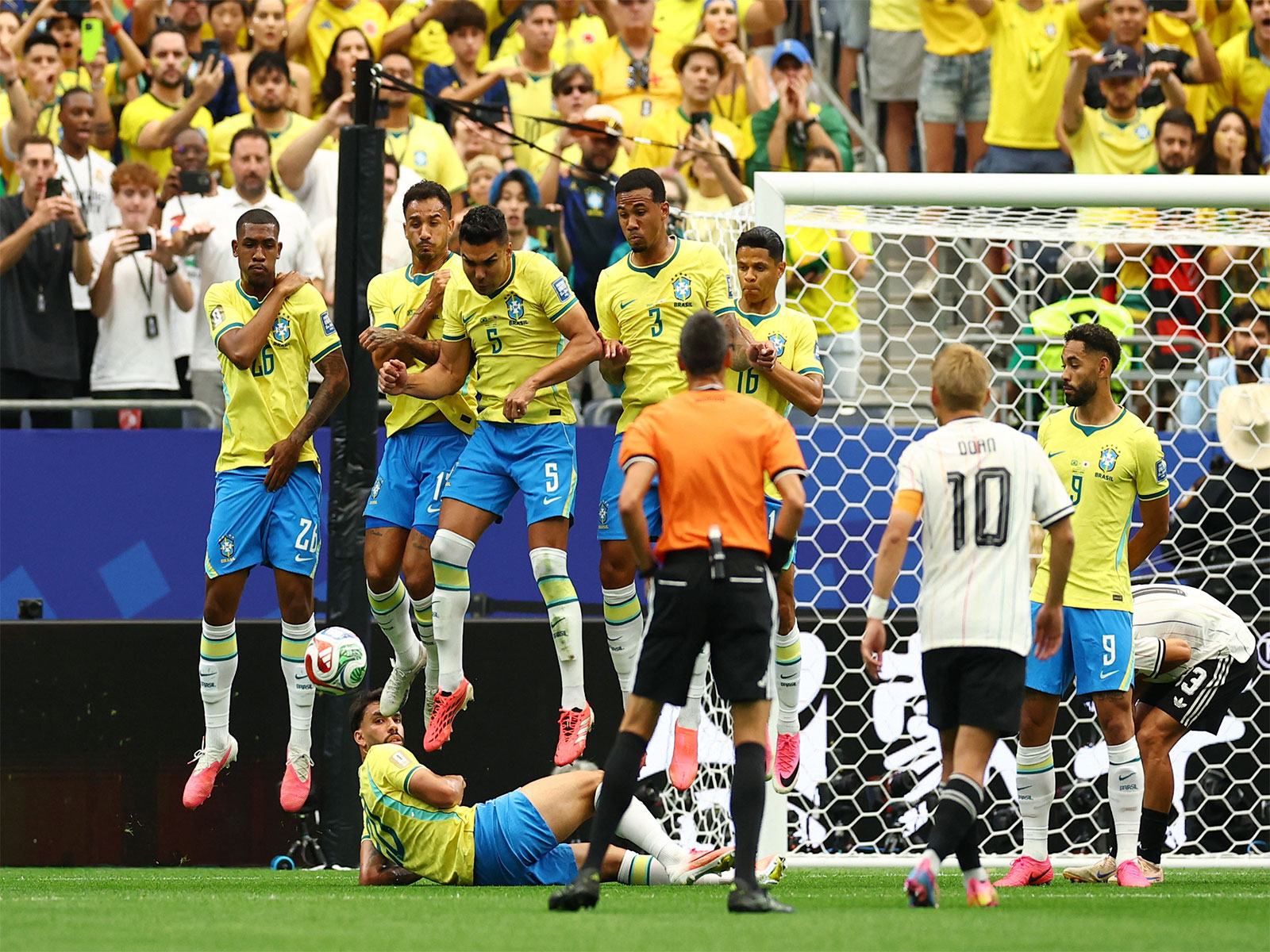 Brazil's Casemiro and teammates jump in a defensive wall after Japan's Ritsu Doan shoots at goal from a free kick. (Photo/Reuters)