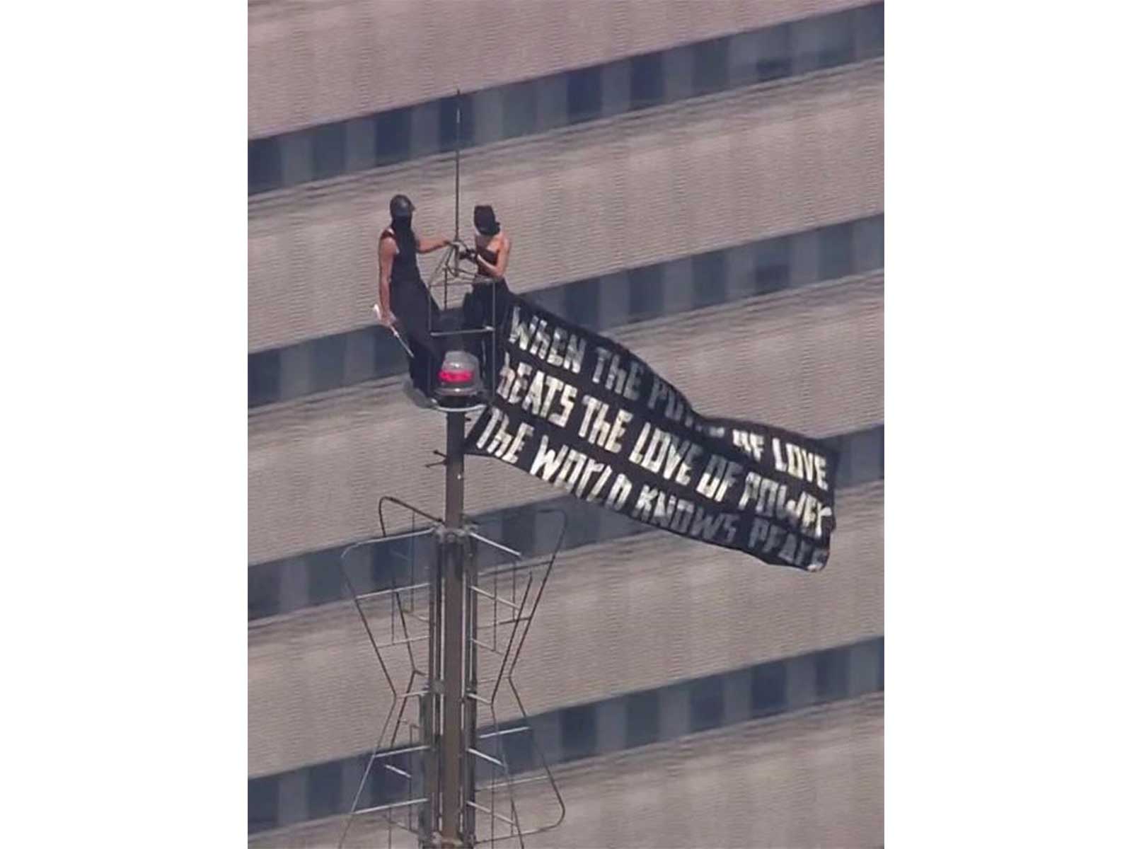Two people scale to the top of Empire State Building carrying banner (Photo/Instagram/@angela_nikolau)