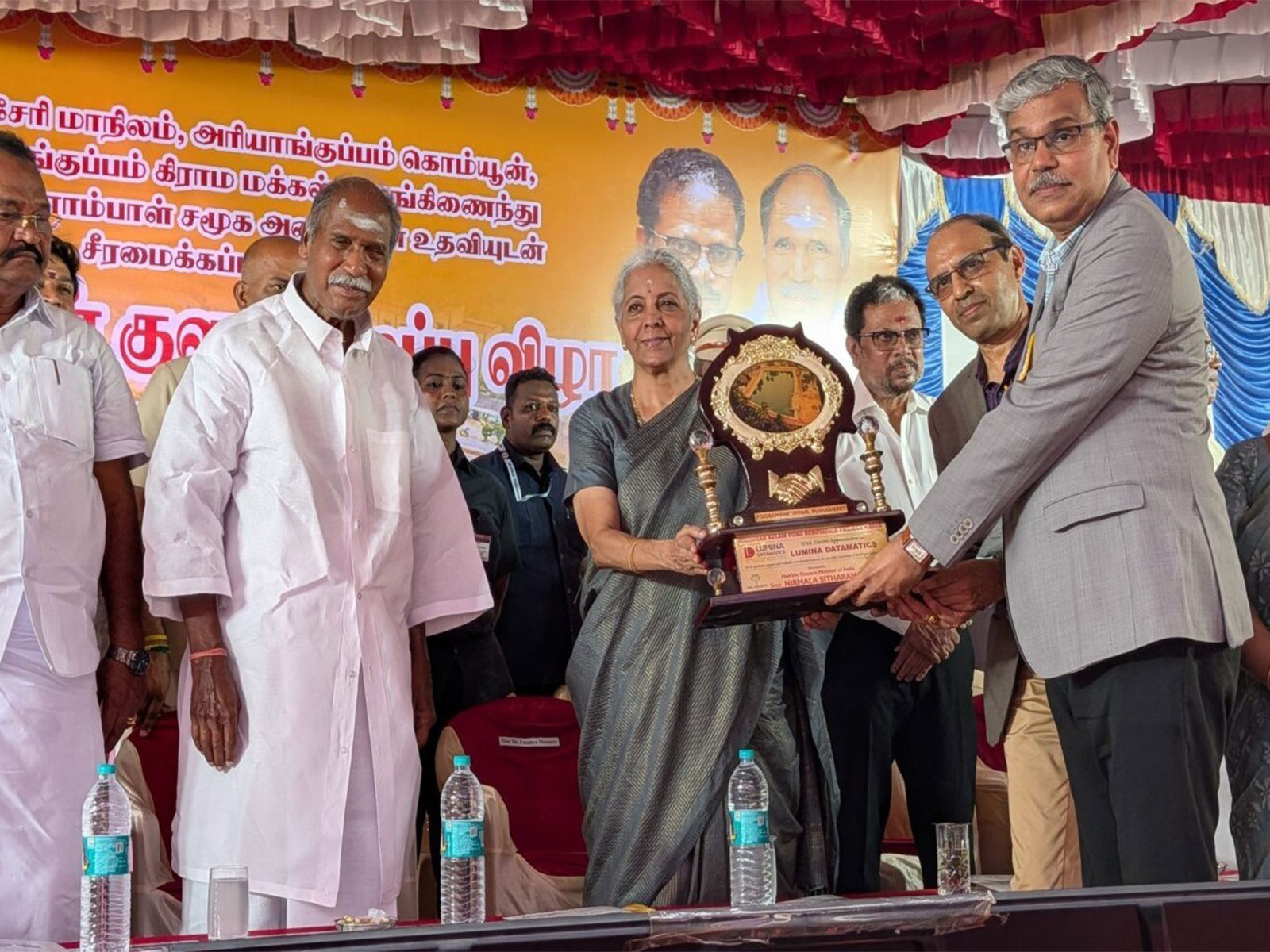 Union Finance Minister Nirmala Sitharaman presents a memento to Lumina Datamatics executives Srinivas Rao and Piyush Kumar at the inauguration of the restored Muzhiyan Kulam in Puducherry