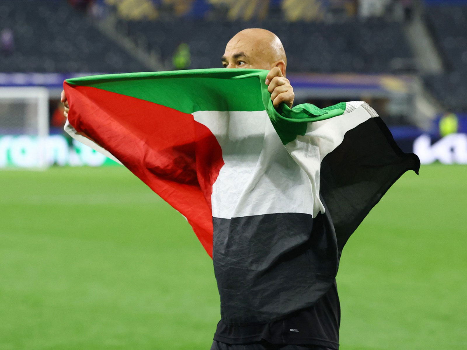 Soccer Football - FIFA World Cup 2026 - Round of 32 - Australia v Egypt - Dallas Stadium, Arlington, Texas, U.S. - July 3, 2026 Egypt coach Hossam Hassan celebrates with a Palestine flag after the R32 match. (Photo: Reuters)