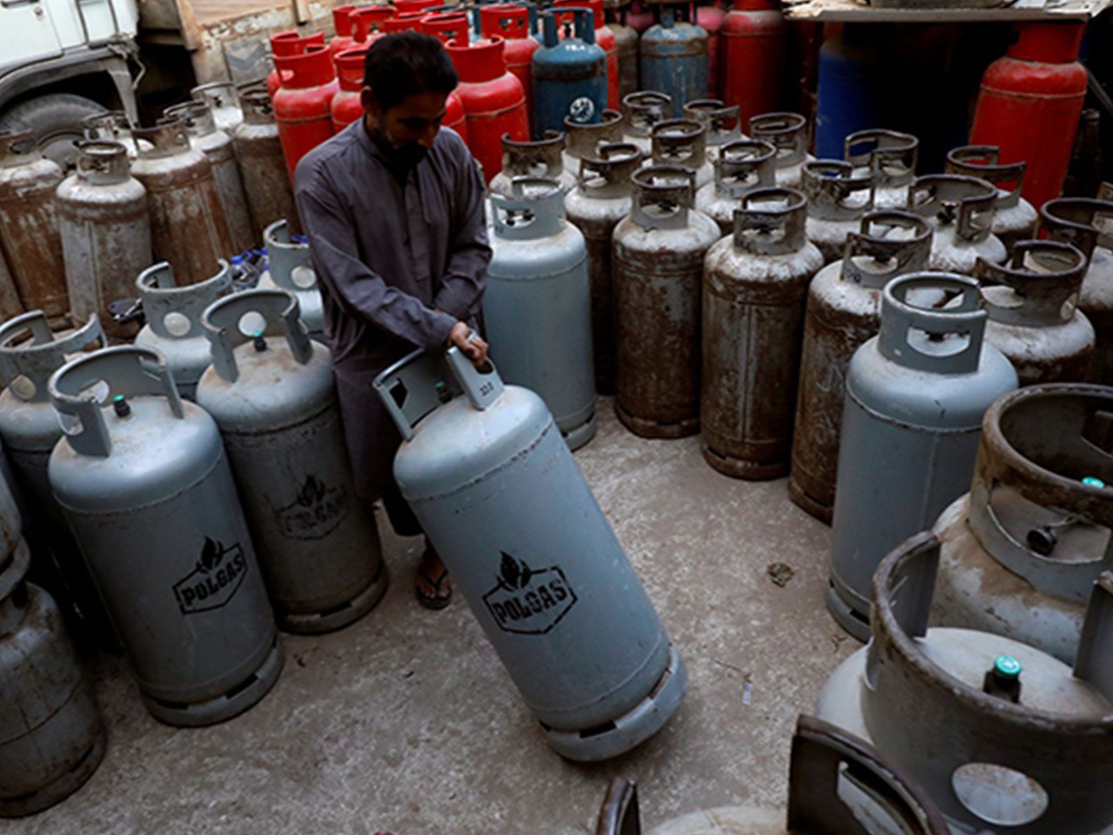 A worker moves a liquid petroleum gas (LPG) cylinder at a workshop in Karachi (Photo/Reuters)