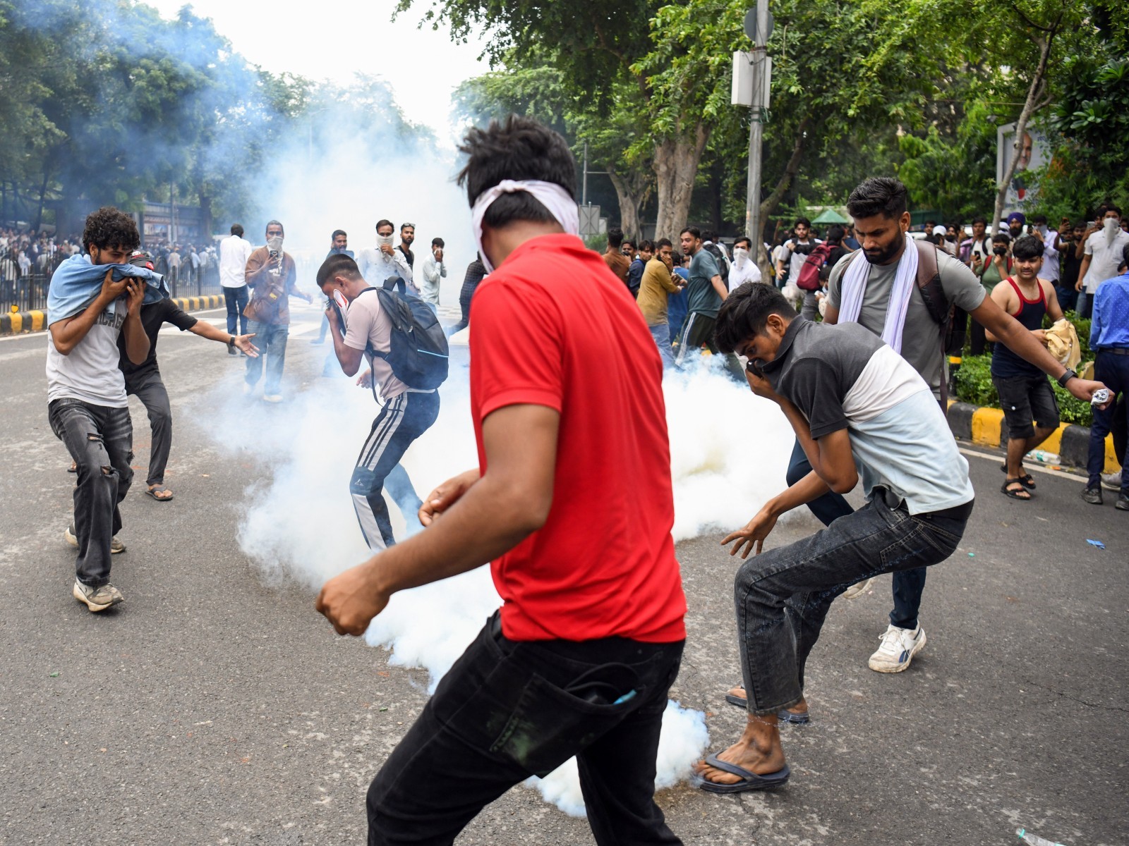 Protestors cover their face as security personnel fire tear gas shells on them during their protest march towards Parliament (File Photo/ANI)