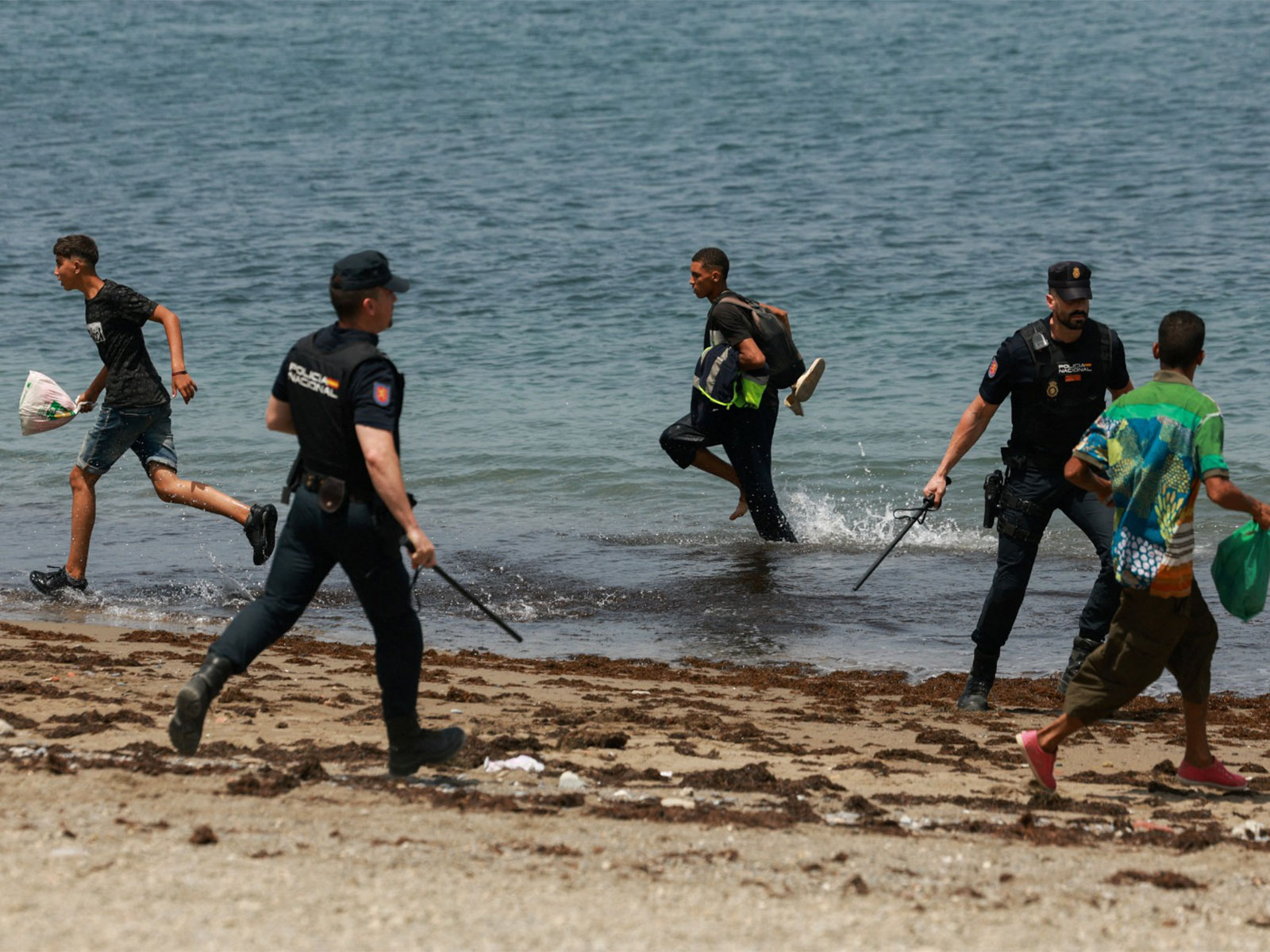 Migrants try to make their way past Spanish police officers, following recent mass crossings of migrants on foot and by sea from Morocco into Spanish territory, in Ceuta, Spain (Photo/Reuters)