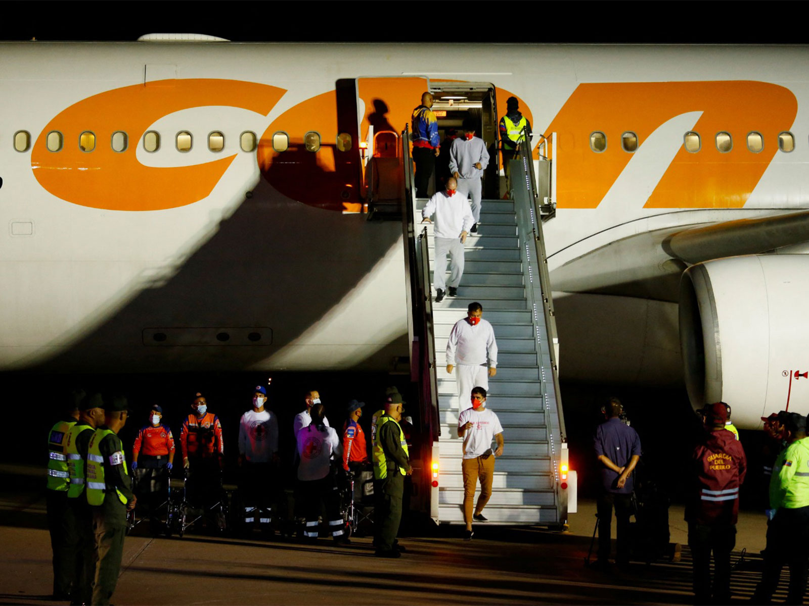 Venezuelan migrants walk following their arrival on a flight after being deported from the United States, in Caracas, Venezuela, in March (File Photo/Reuters)