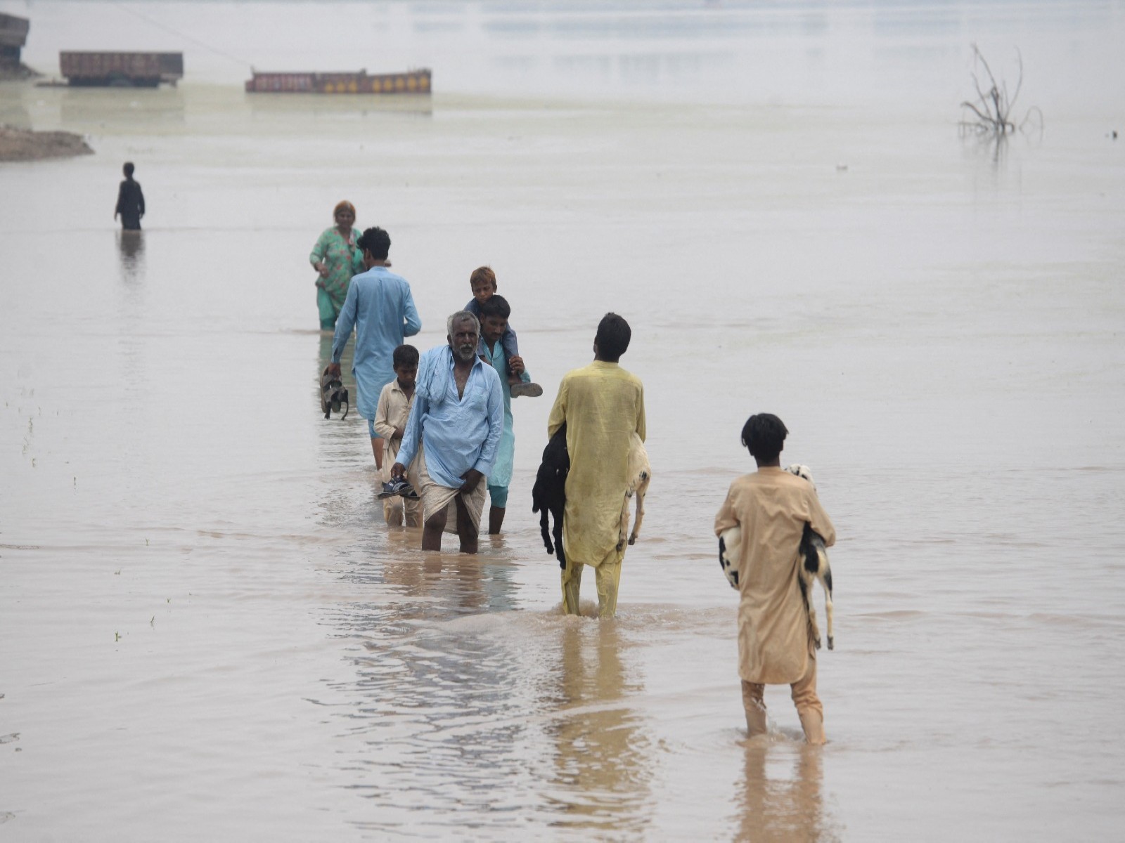People wade through a flooded road (File Photo/.Reuters)
