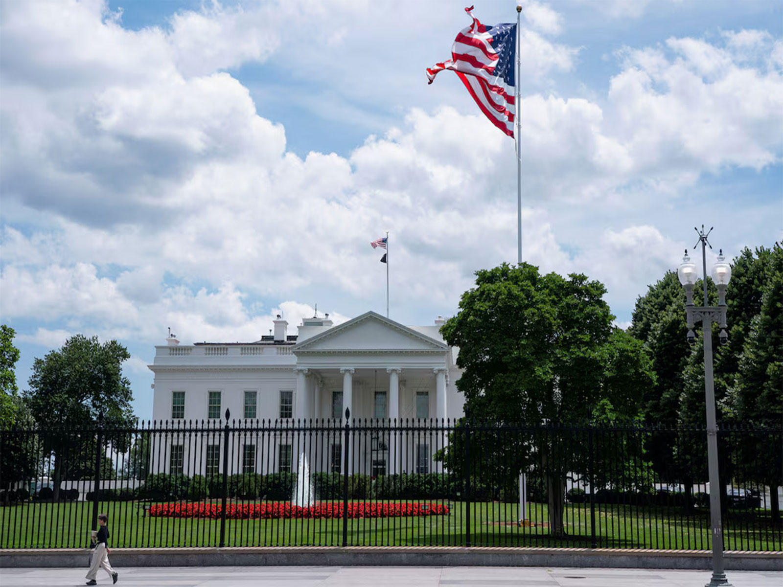 A visitor walks past the White House and a newly installed flagpole on the North Lawn in Washington, DC, US. (Photo/Reuters)