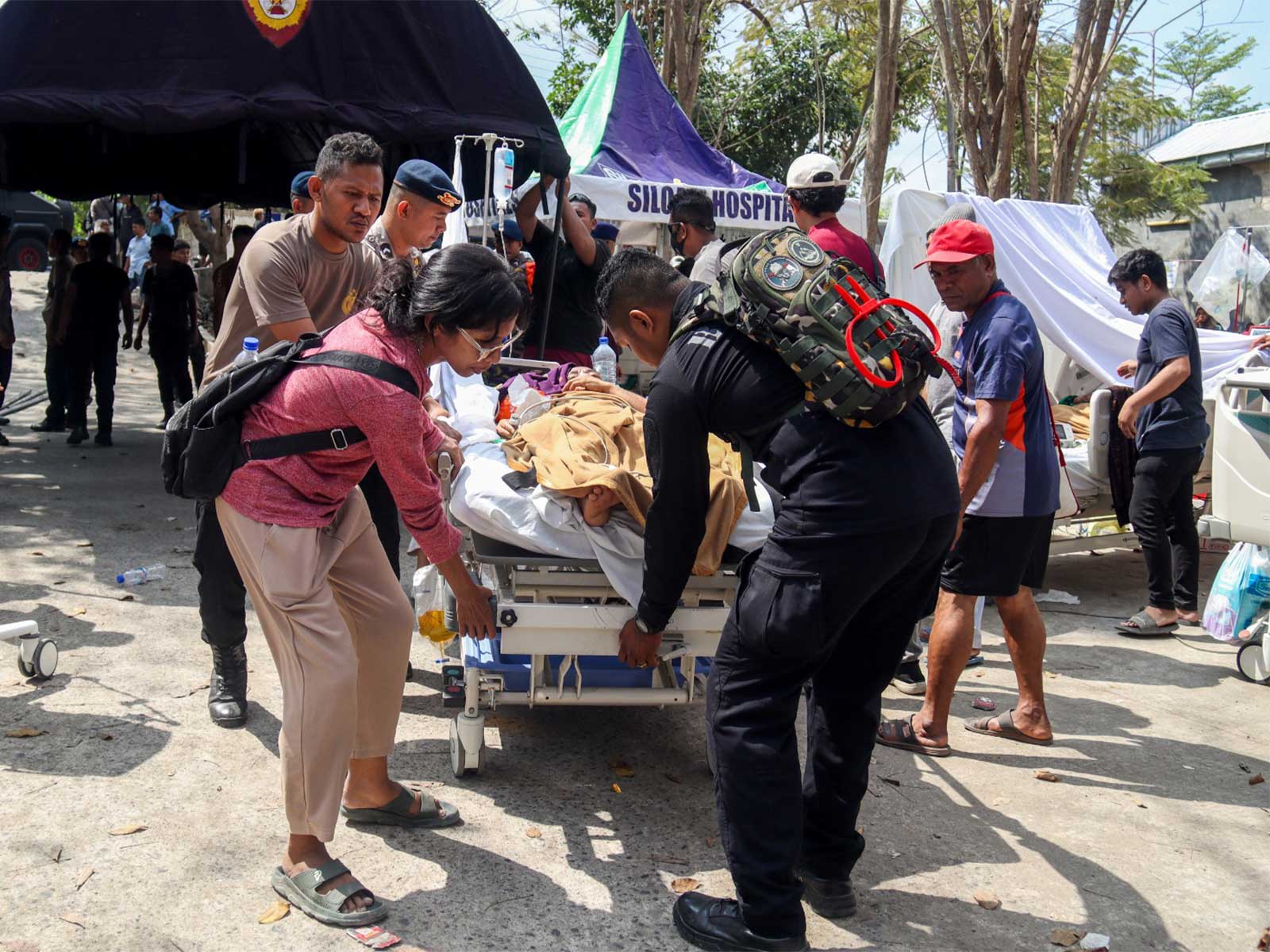 Police officers help move a patient to an open-area shelter at a hospital, following an earthquake felt in Labuan Bajo, Indonesia (Photo/Reuters)