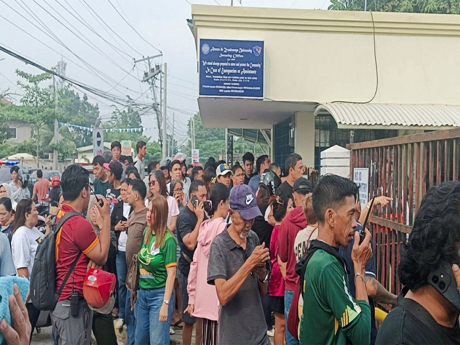 People stand outside Ateneo de Zamboanga University after a shooting that killed two people, in Zamboanga, southern Philippines (Photo/Reuters)