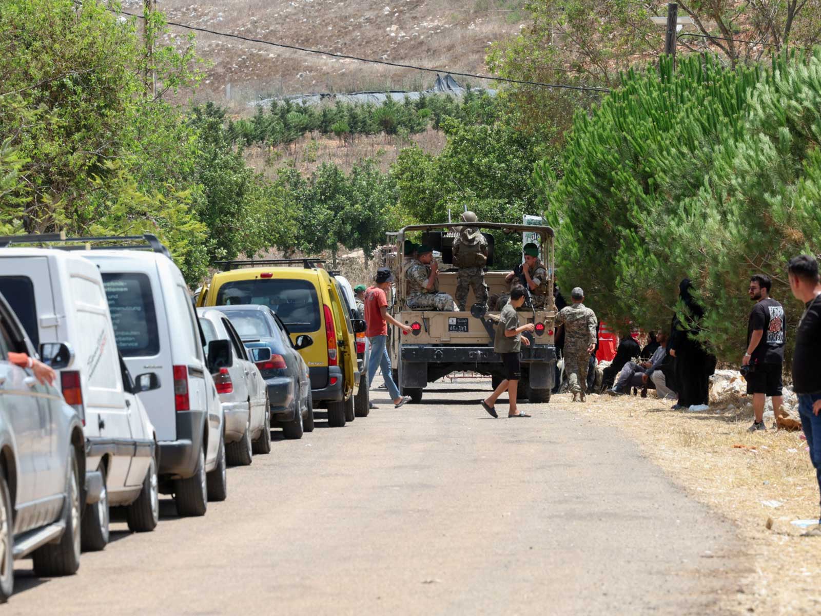    Lebanese soldiers ride in a vehicle as residents wait to enter the town of Zawtar al-Gharbiyeh, following the withdrawal of Israeli forces under a U.S.-brokered plan, in southern Lebanon (File Photo/Reuters)