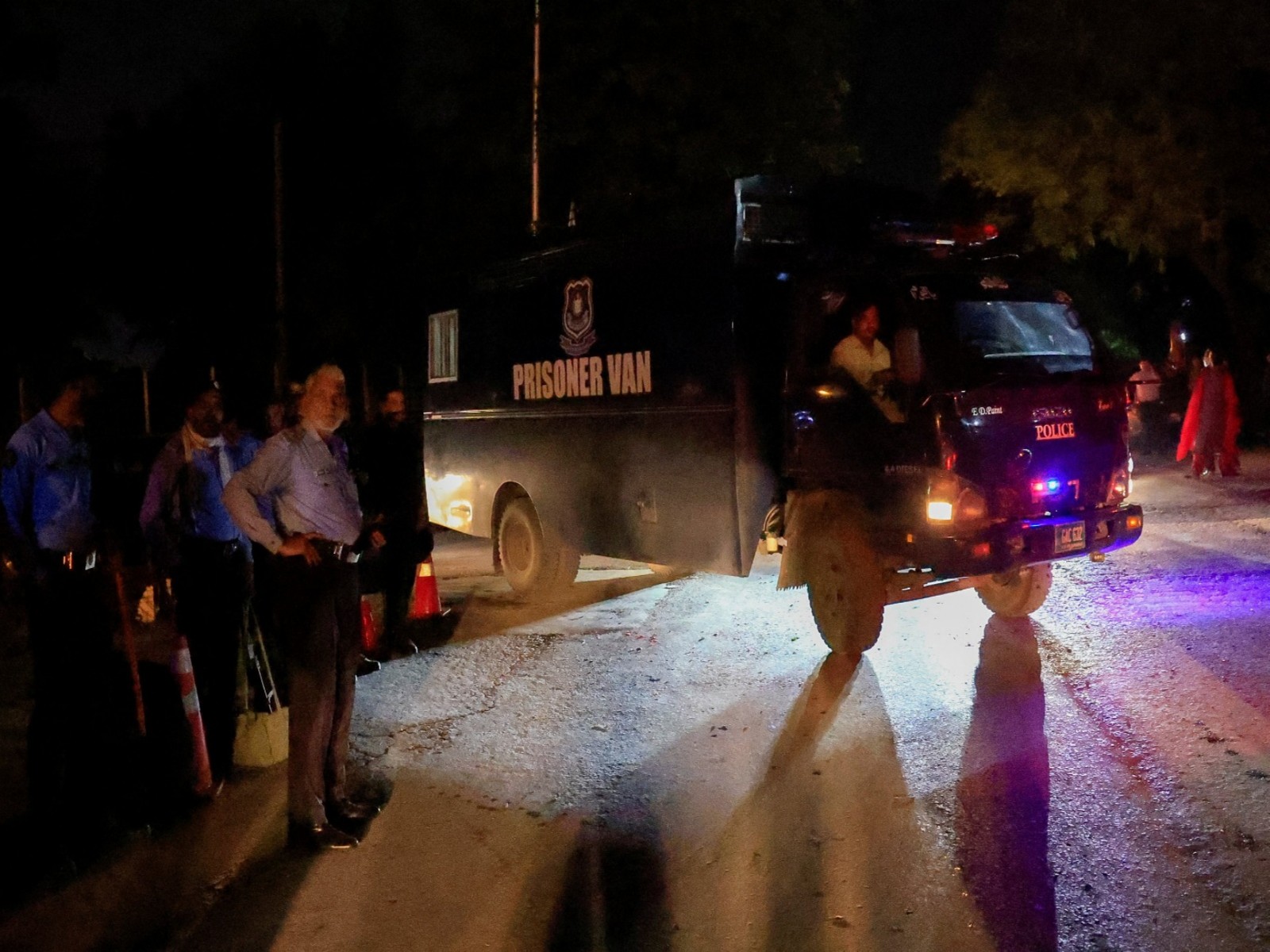 A prison van moves past police officers guarding the road leading to Shifa International Hospital after the Supreme Court ordered authorities to move jailed former Pakistani Prime Minister Imran Khan to the hospital (Photo/Reuters)
