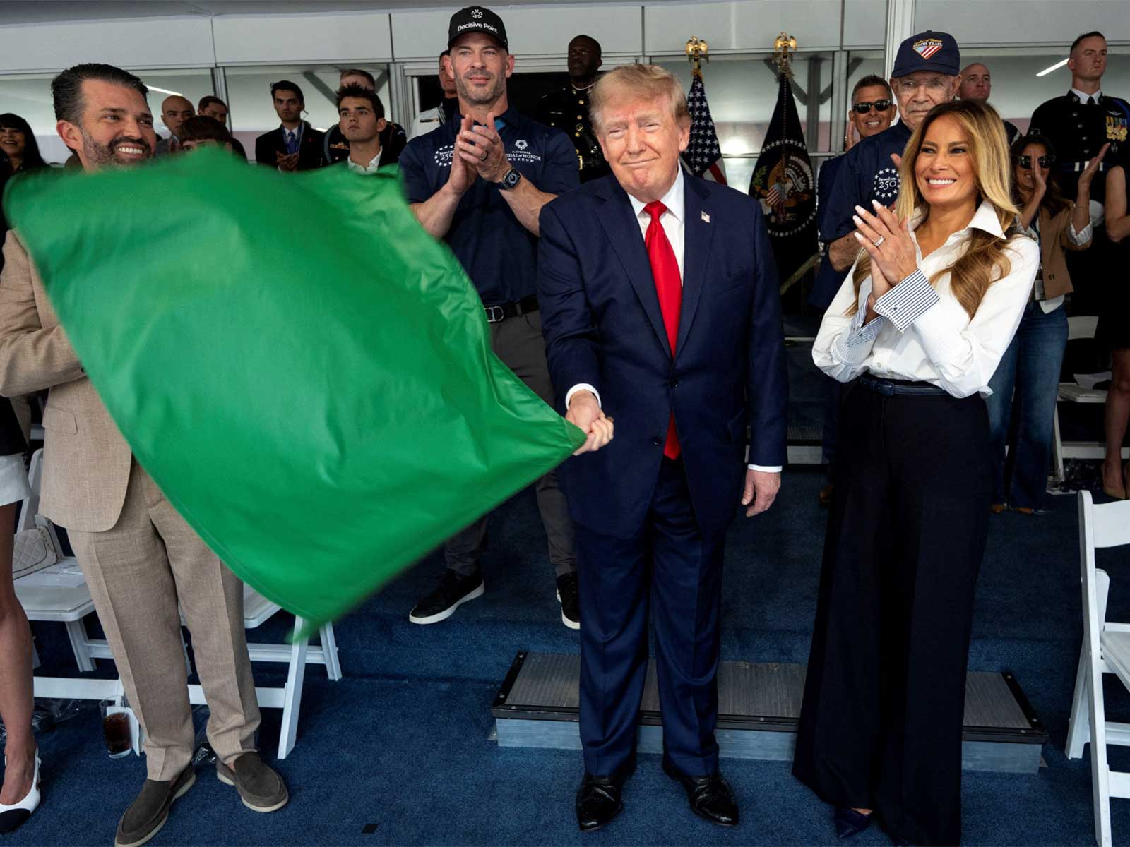 US President Donald Trump waves the green flag to start the race with First Lady Melania Trump at his side, during the Freedom 250 Grand Prix Race on the streets of Washington, DC (Photo/Reuters)