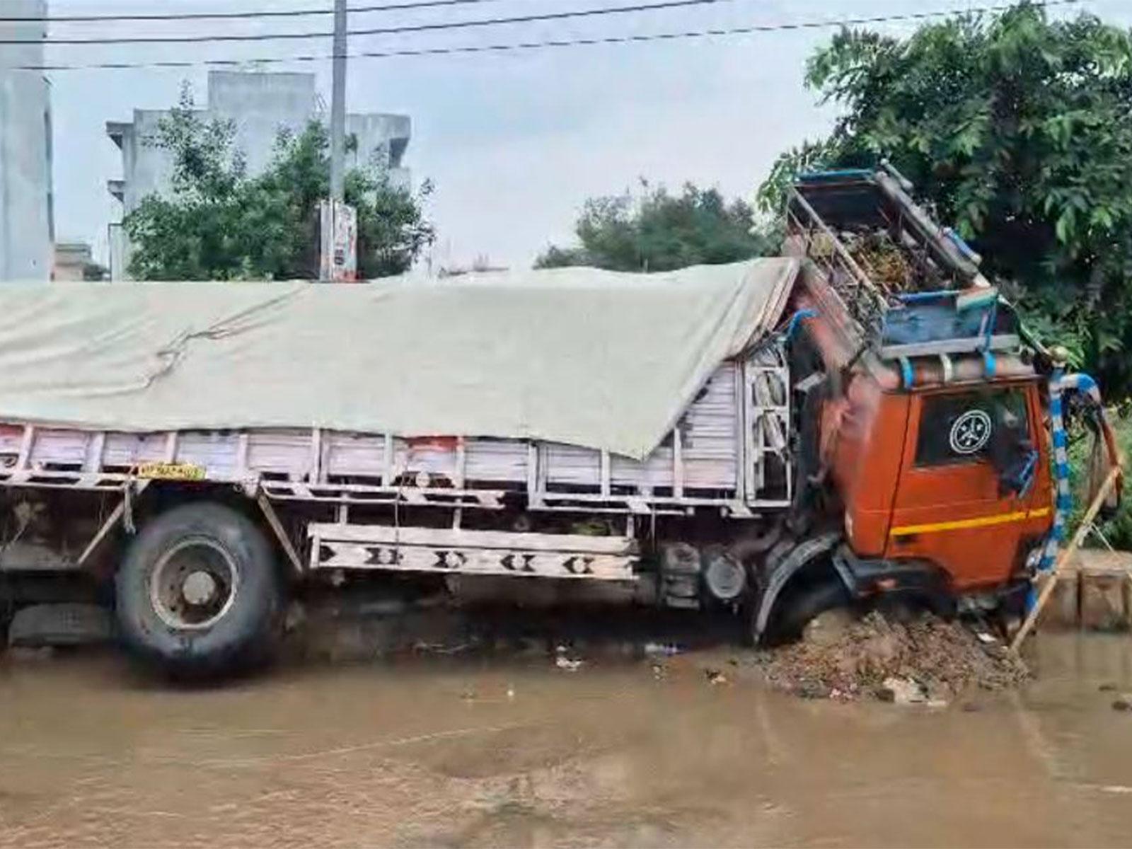 Haryana: Cement-laden truck sinks into waterlogged road in Gurugram's Sector 9 following heavy rain (Photo/ANI)