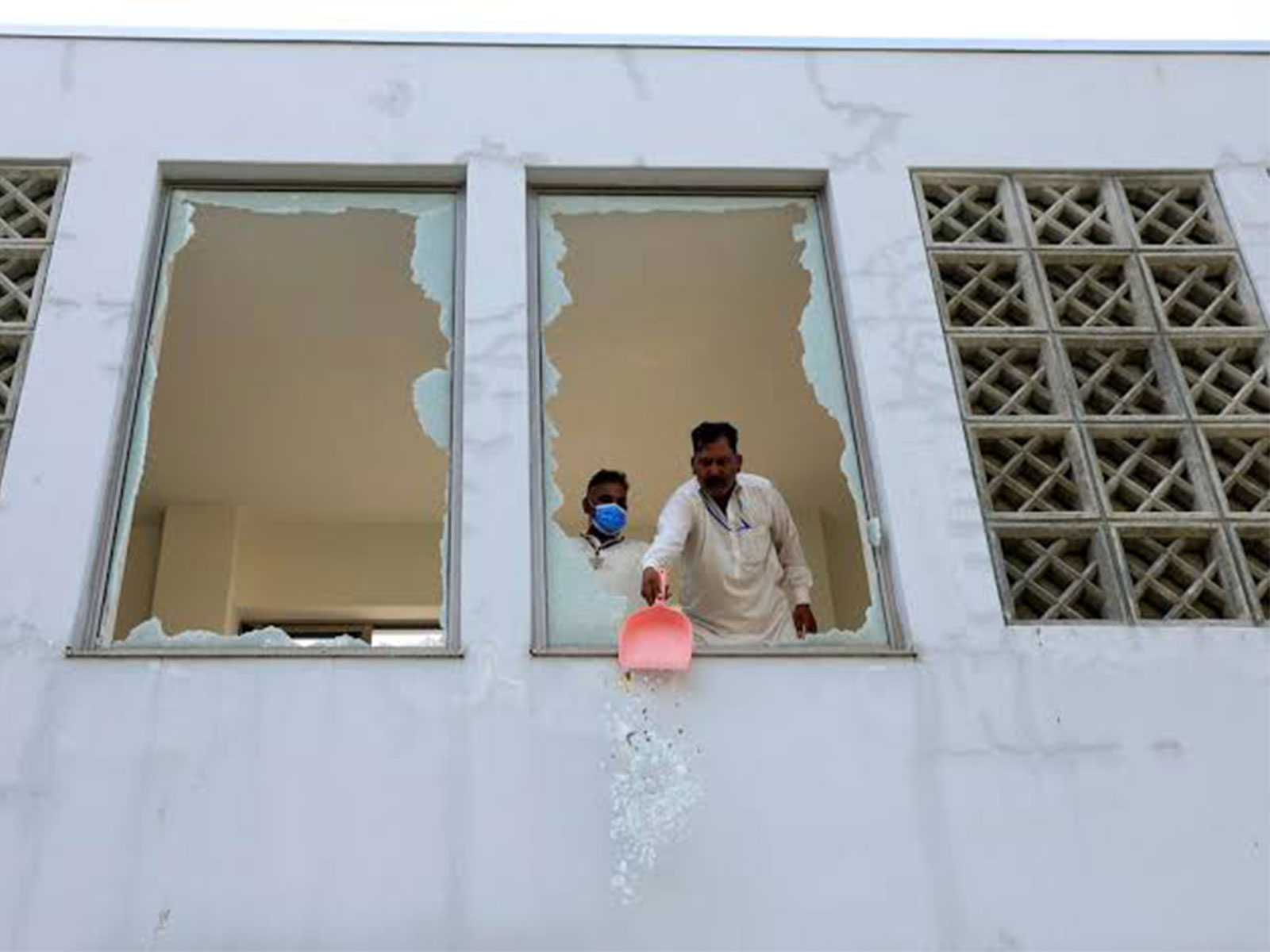 A worker clears shattered glass from a window following a fire at the Pakistan Institute of Medical Sciences (PIMS) hospital in Islamabad, Pakistan. (Photo/Reuters)