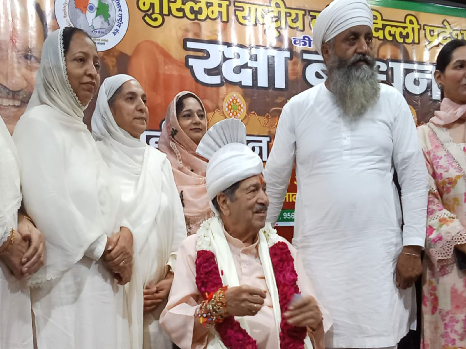 Muslim women tie Rakhi to RSS leader Indresh Kumar during a Rakshabandhan programme at Ghalib Auditorium in Delhi (Photo/ANI)