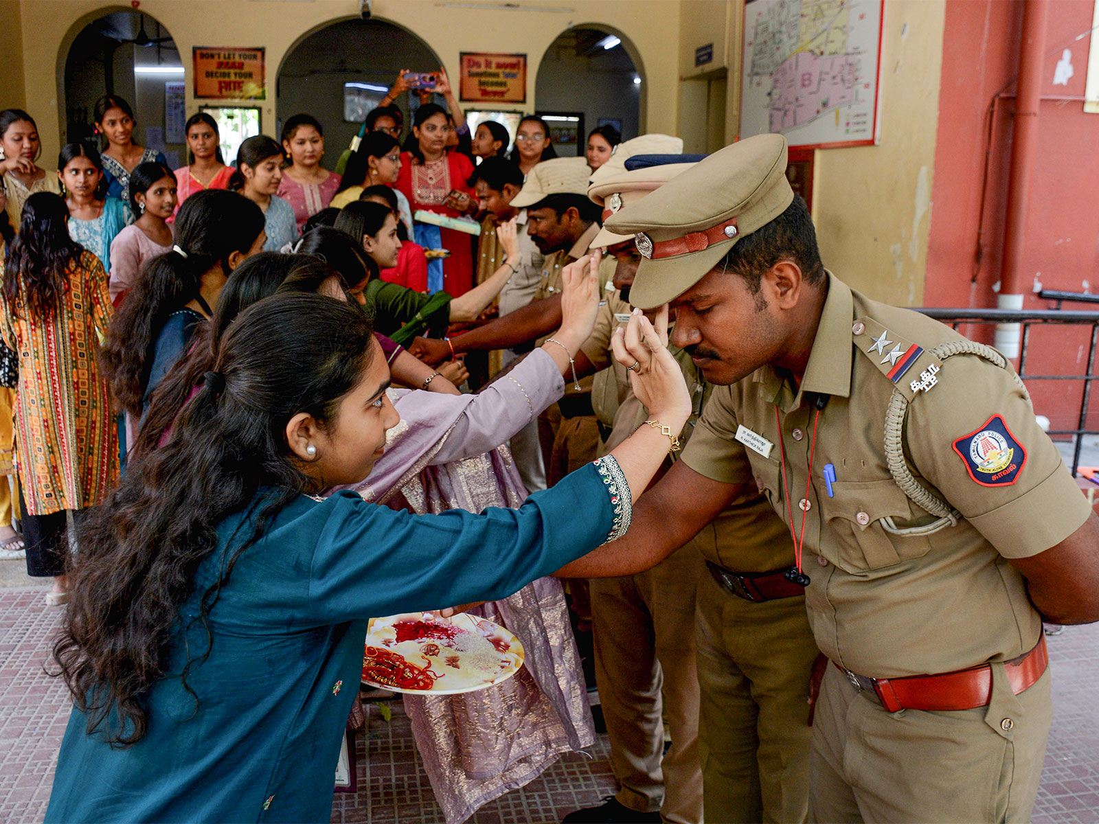 Students tie rakhis to police personnel on the eve of Raksha Bandhan festival (Photo: ANI)
